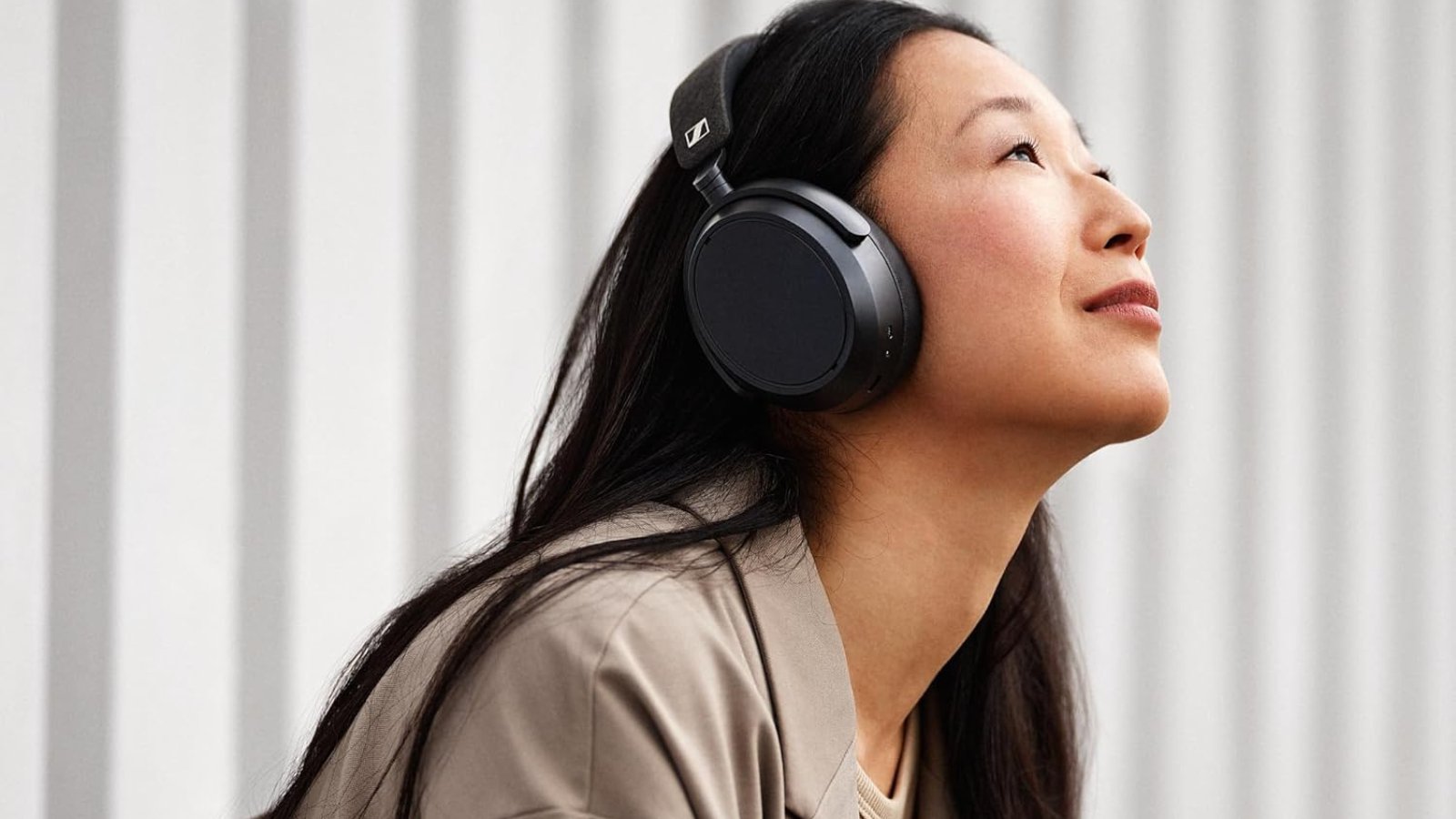 woman wearing black sennheiser momentum 4 headphones