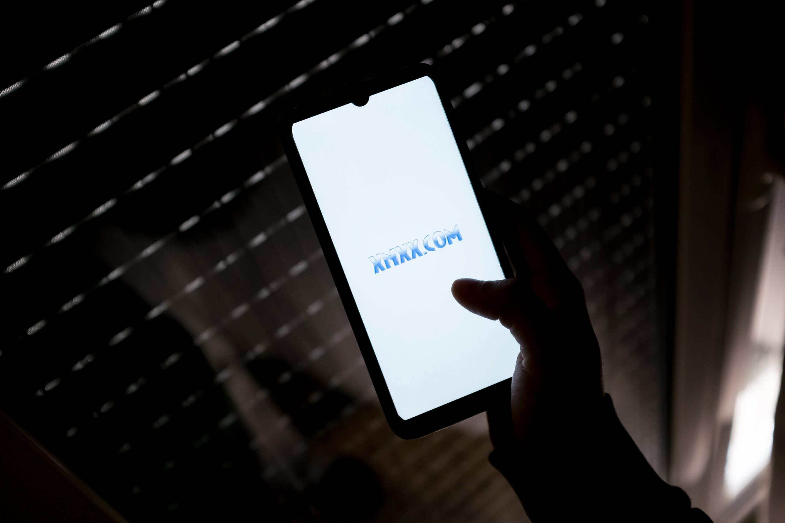 In this photo illustration a XNXX.COM logo seen displayed on a smartphone