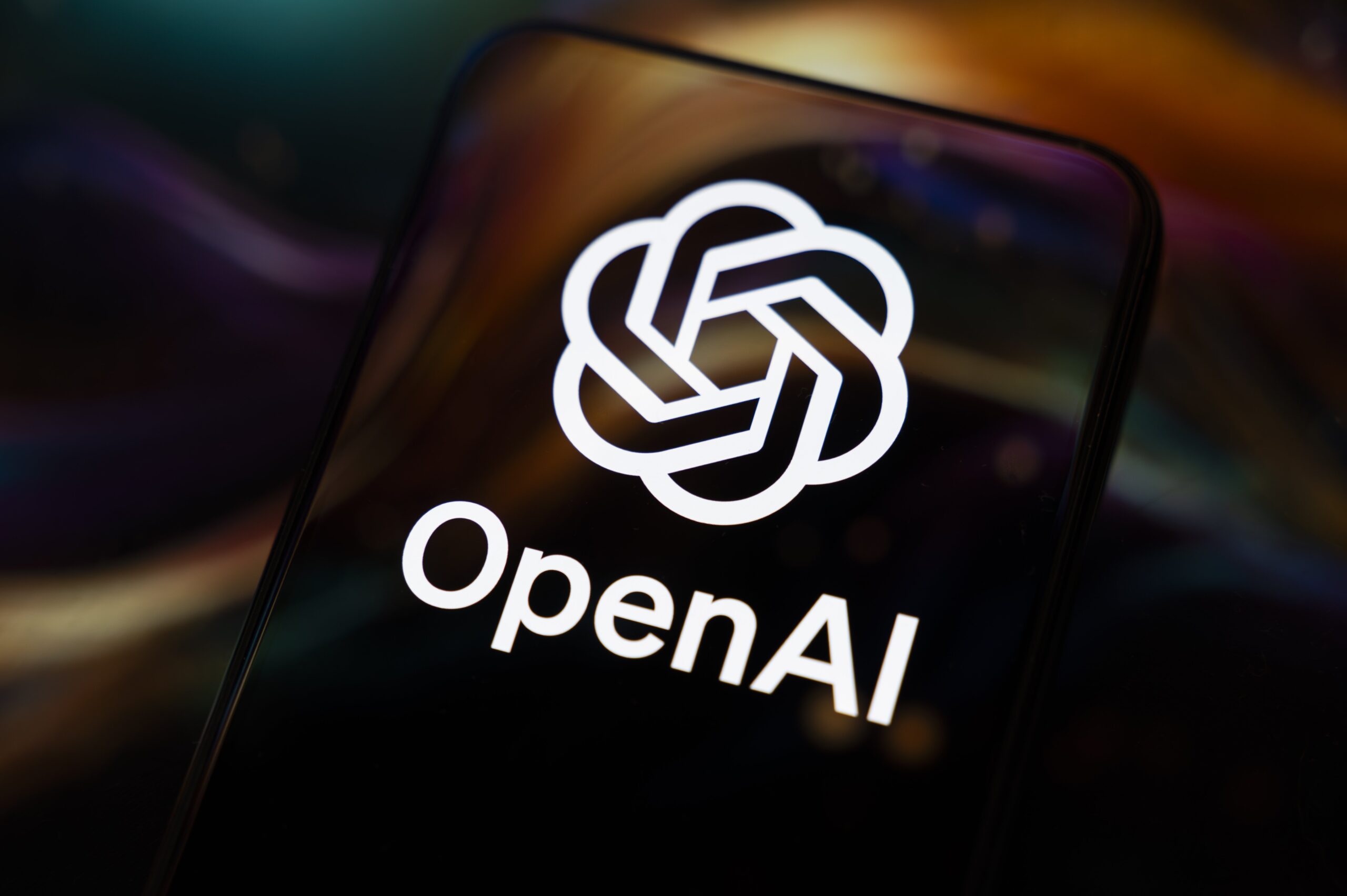 A phone shows the OpenAI logo.