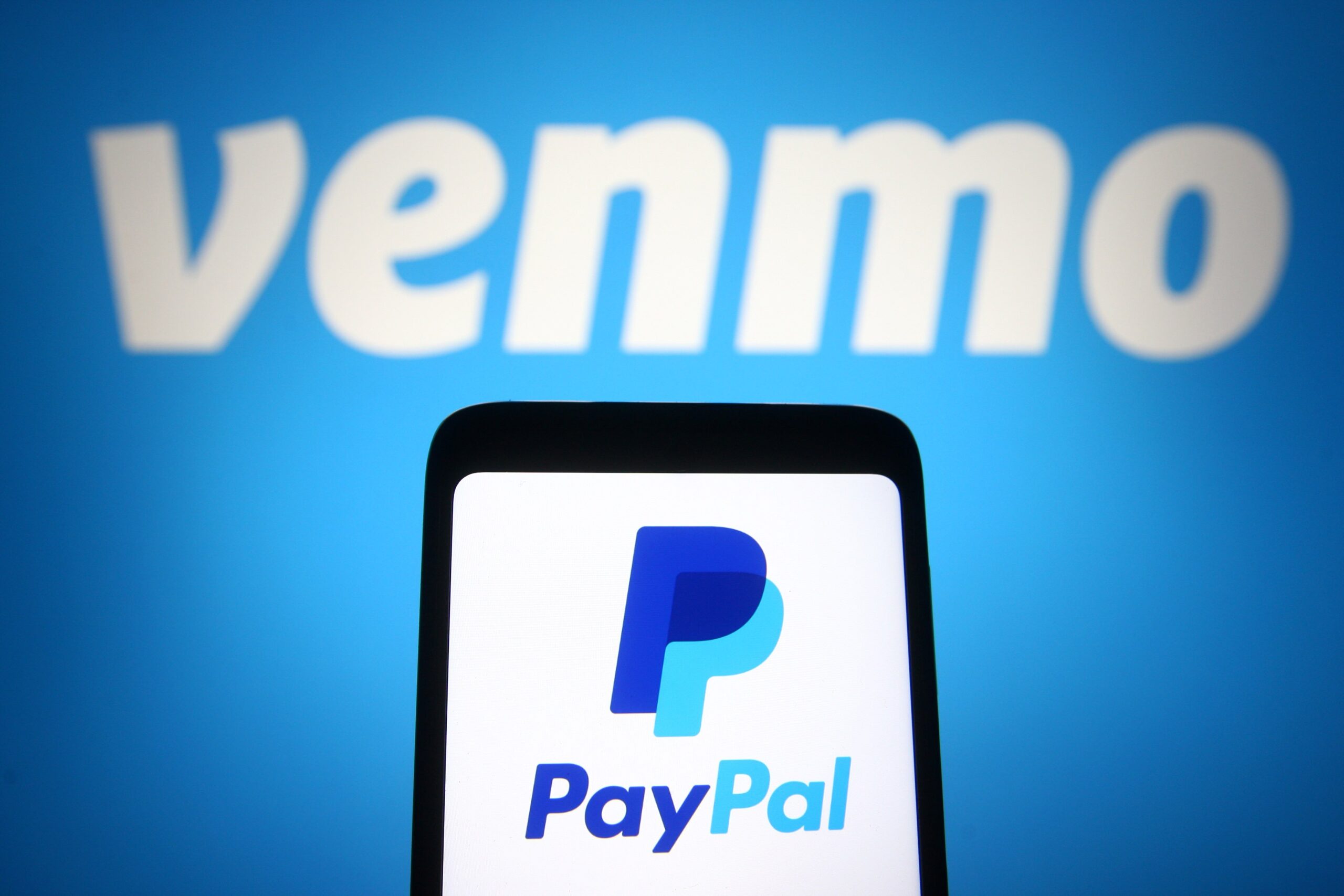 the paypal logo on a phone in front of the venmo logo