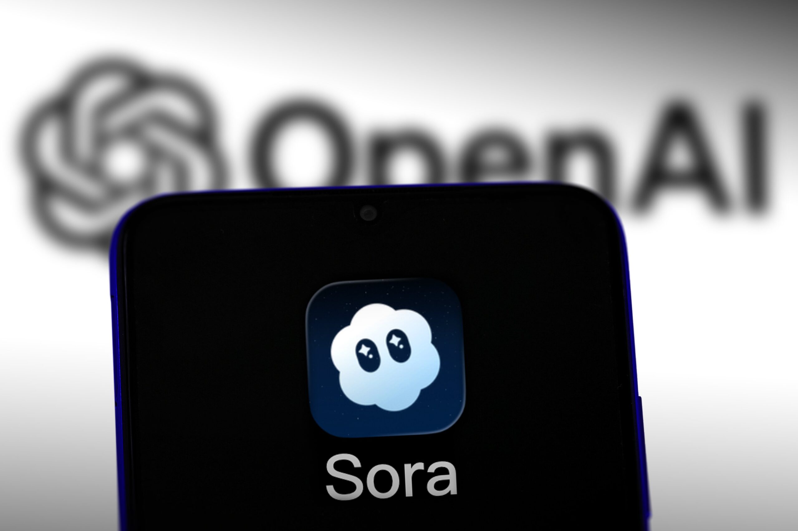 sora logo on phone in front of open ai logo