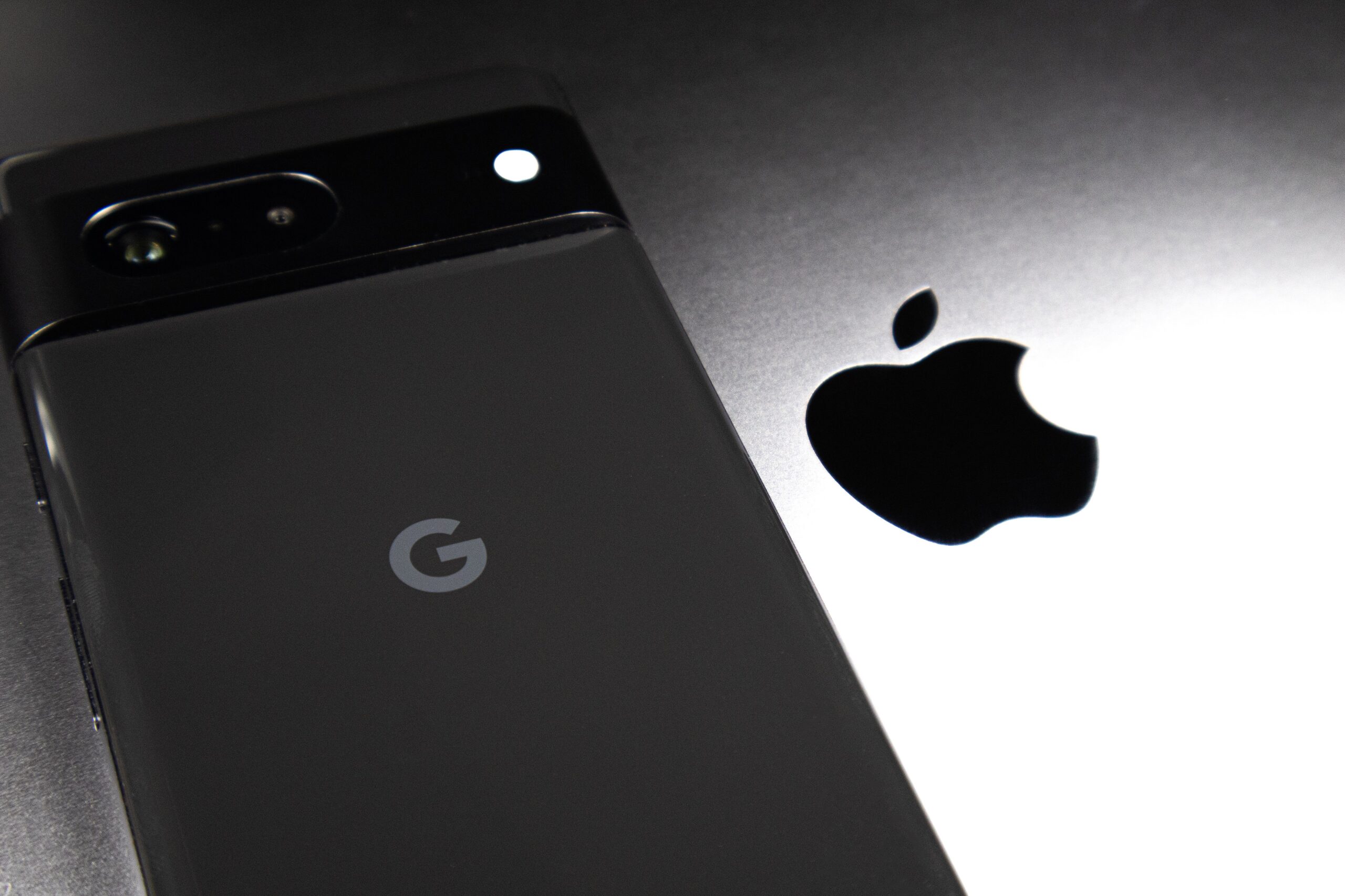 Google Pixel phone next to Apple logo