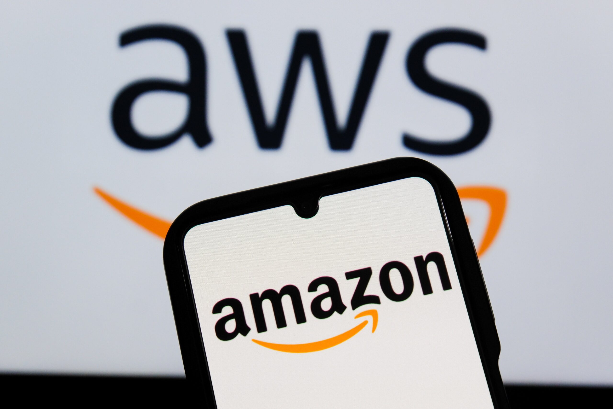 aws logo behind a phone with an amazon logo