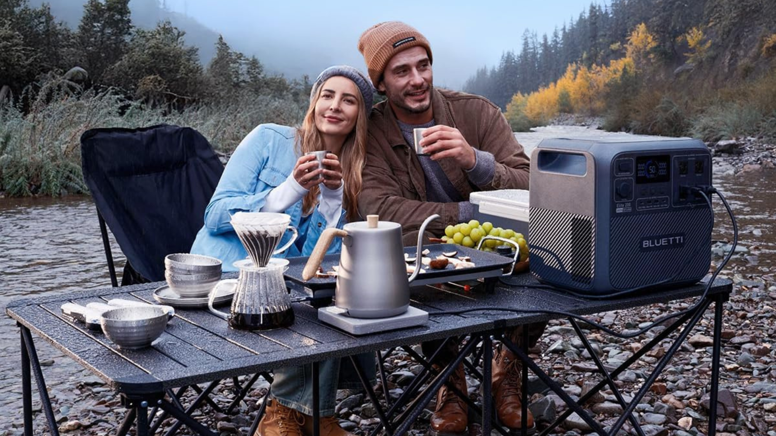 man and woman outside with bluetti solar generator powering up kettle and griddle on table