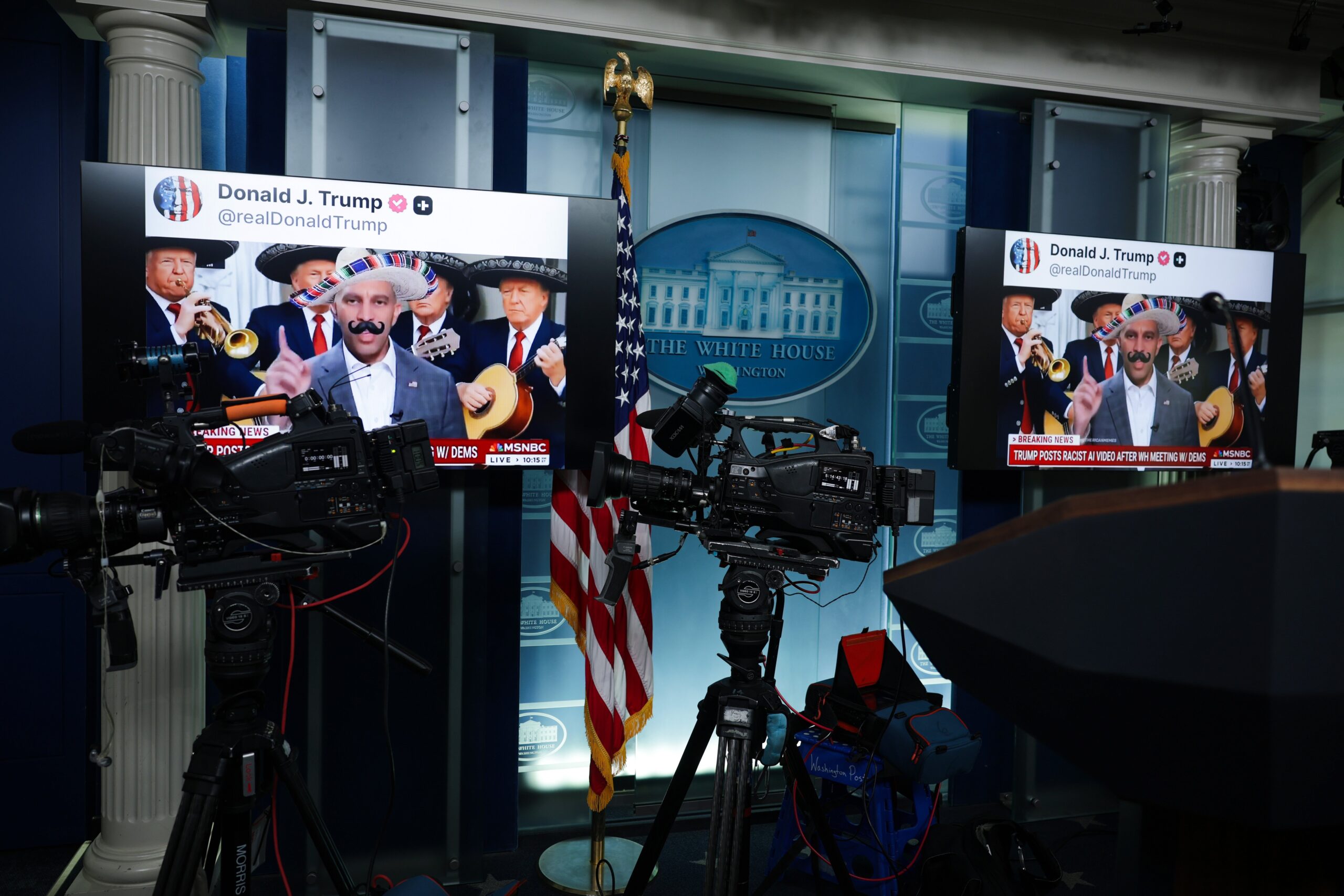 Two monitors in the White House press room show a screenshot of a post by President Trump sharing an AI edited video of House Minority Leader Hakeem Jeffries.