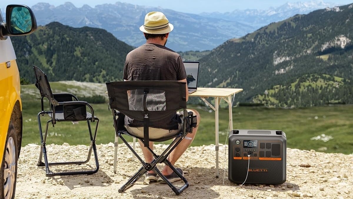 a person uses the Bluetti AC200PL while sitting outside on a sunny day