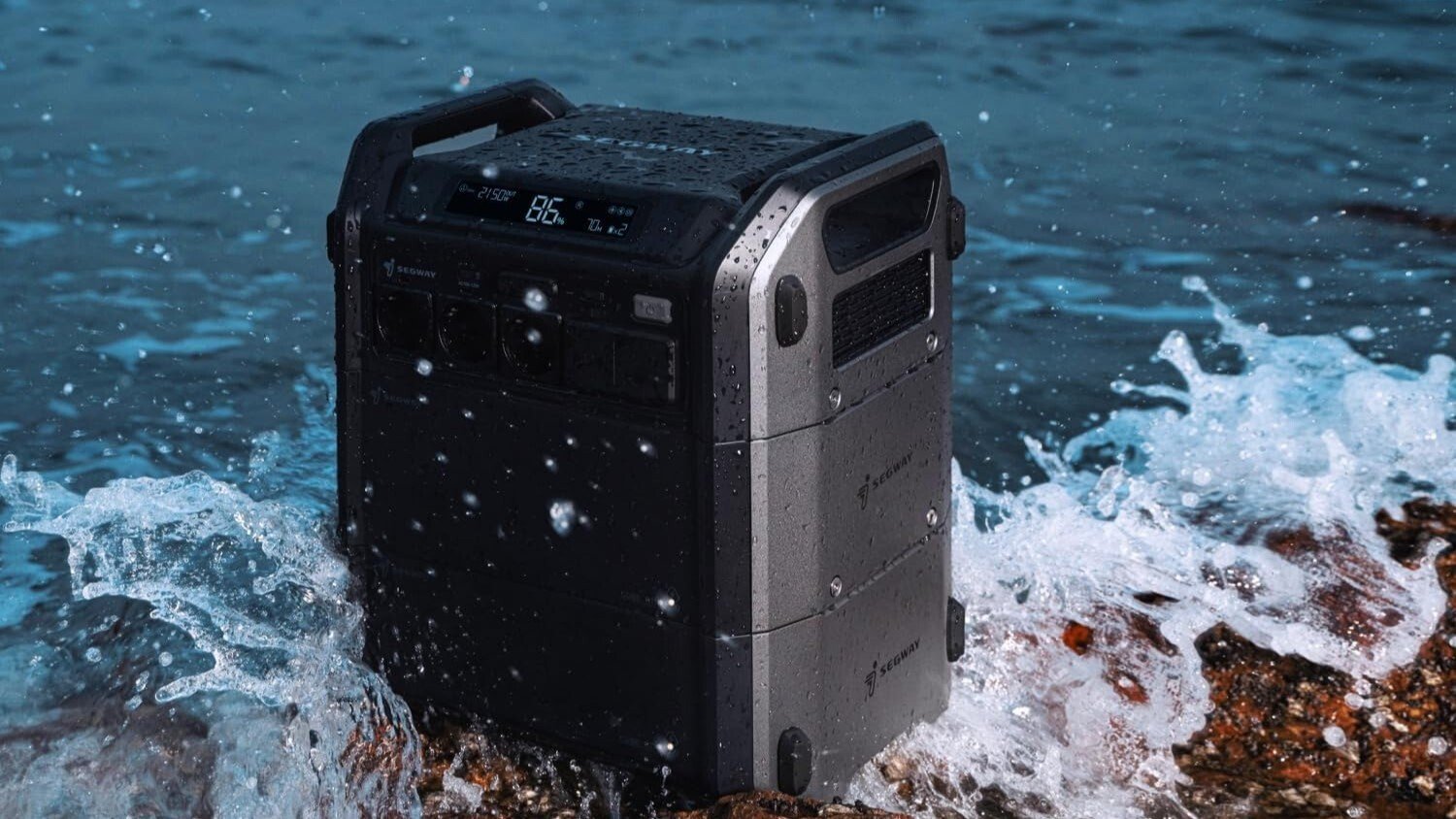 the segway cube 1000 portable power station sitting on rocks in waves near the shoreline