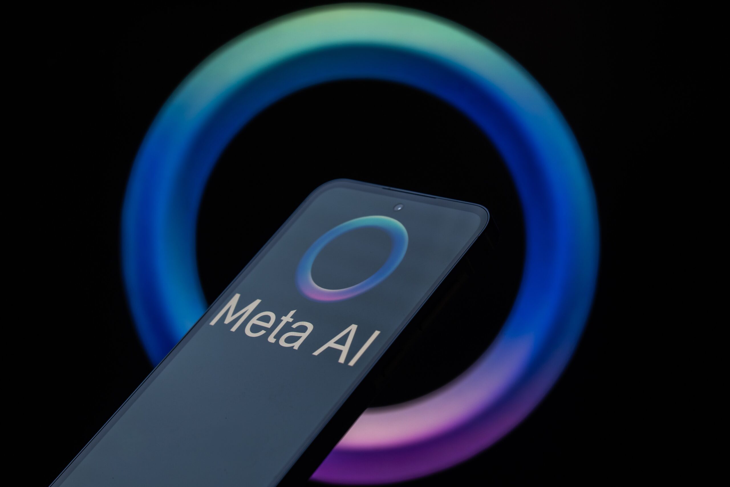 A phone showing the Meta AI logo on a black background.