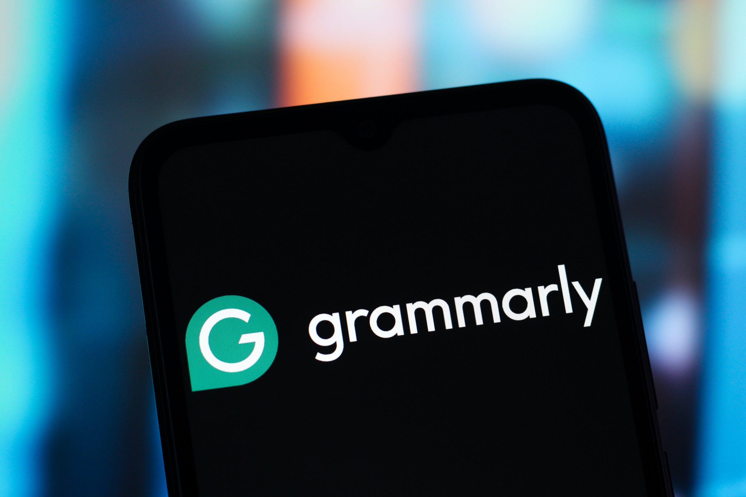 A phone displays the Grammarly logo