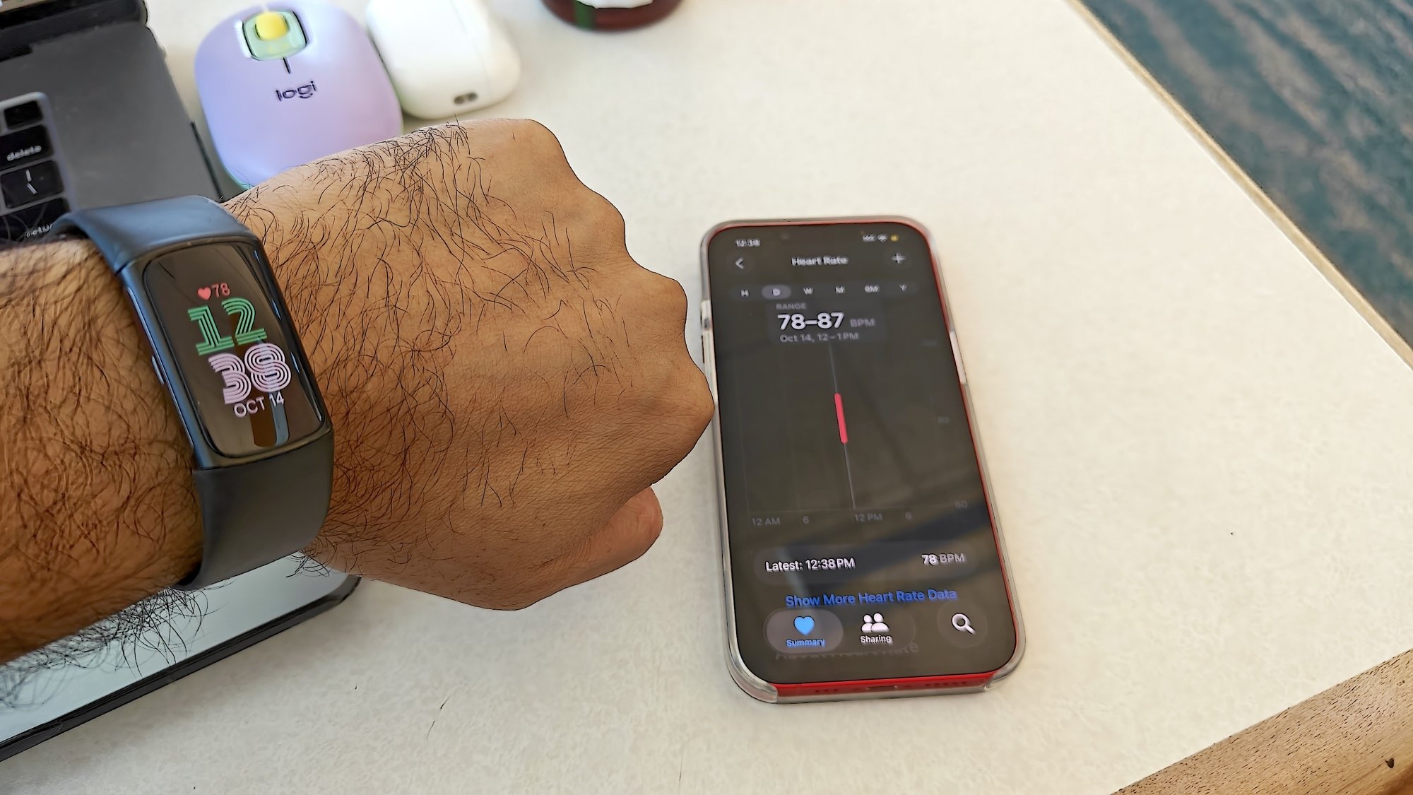 fitbit charge 6 and iphone showing heart rate on their screens