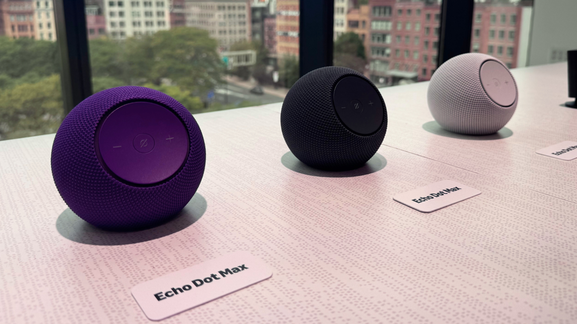 Three Amazon Echo Dot Max smart speakers on a table.