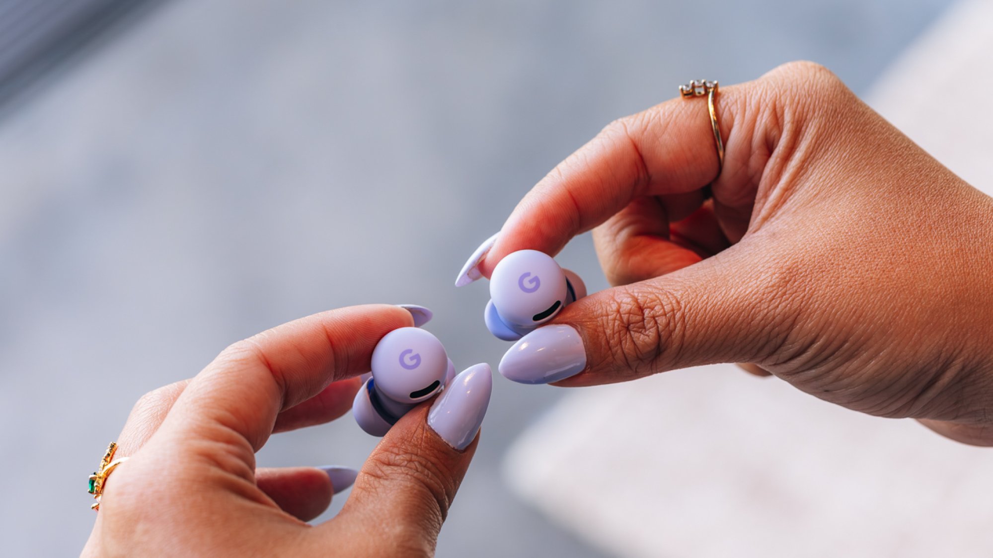 woman with purple nails holds pixel buds 2a in a matching lilac color