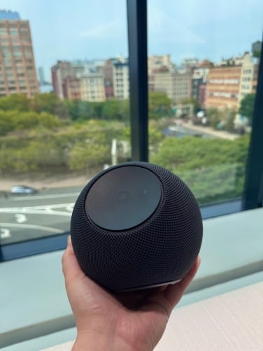 echo studio smart speaker held in hand in front of window