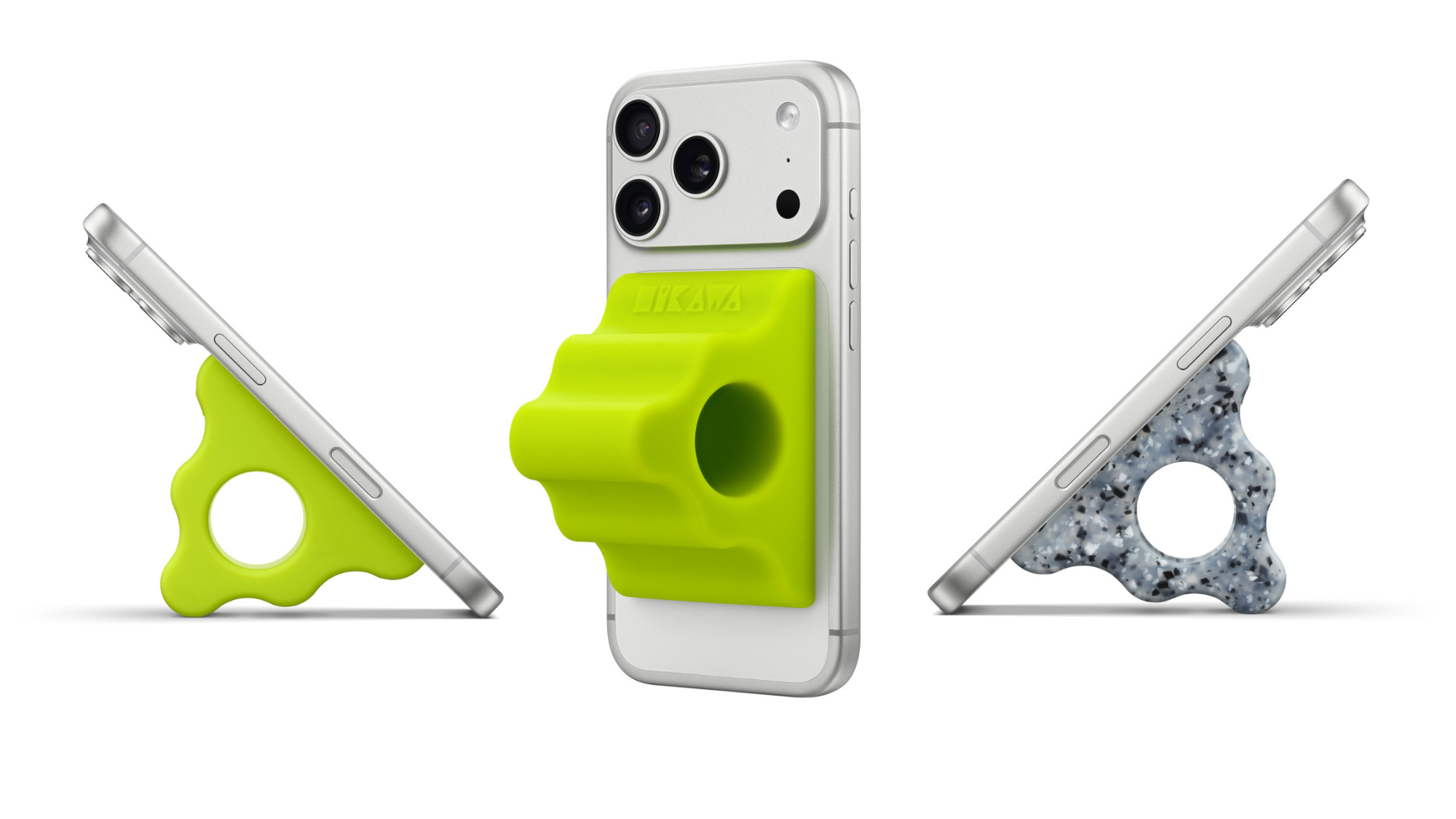 Three iPhones at different angles, each with phone grips magnetized to the back of the device. Two of the grips are bright green while one is a speckled grey pattern. All three are pyramid shaped with a large hole through the center. 