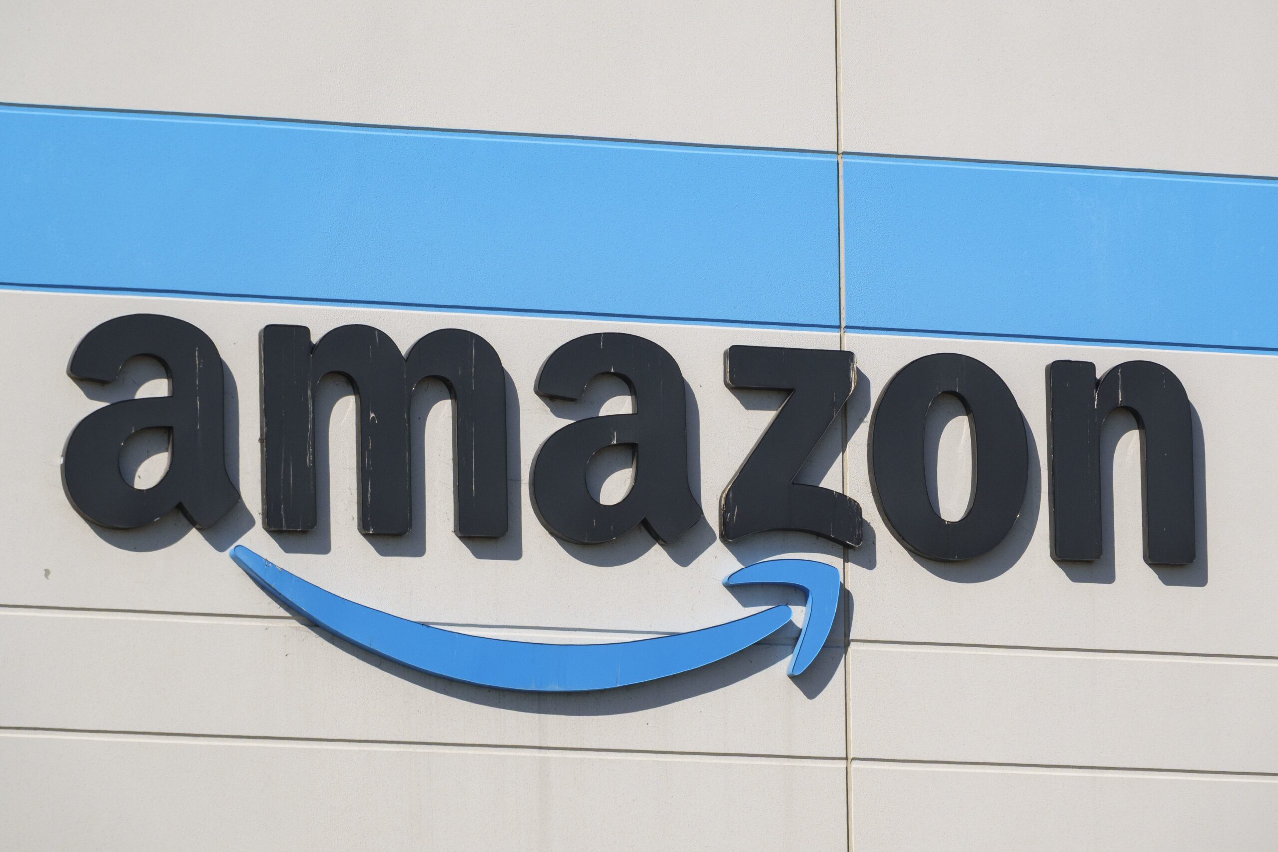 An Amazon logo is displayed outside an Amazon Sortation Center