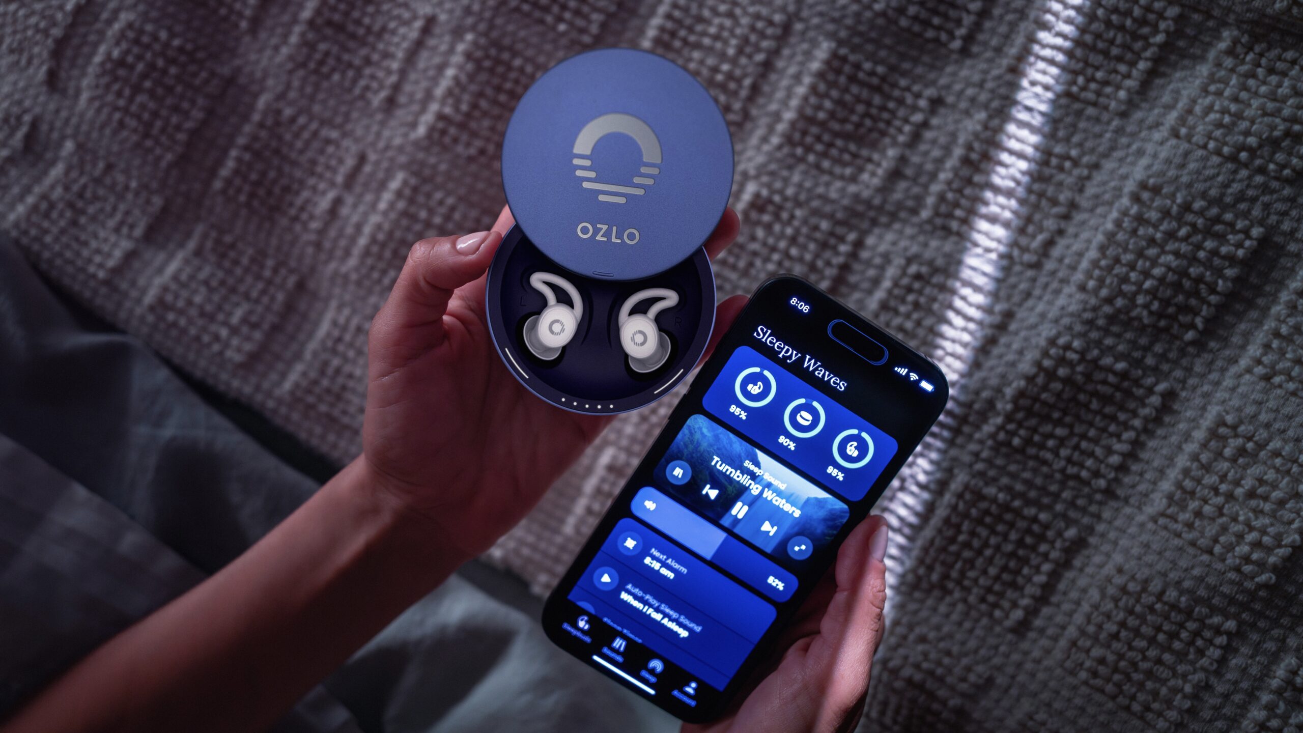 person holding ozlo x calm sleepbuds next to open ozlo app on their phone