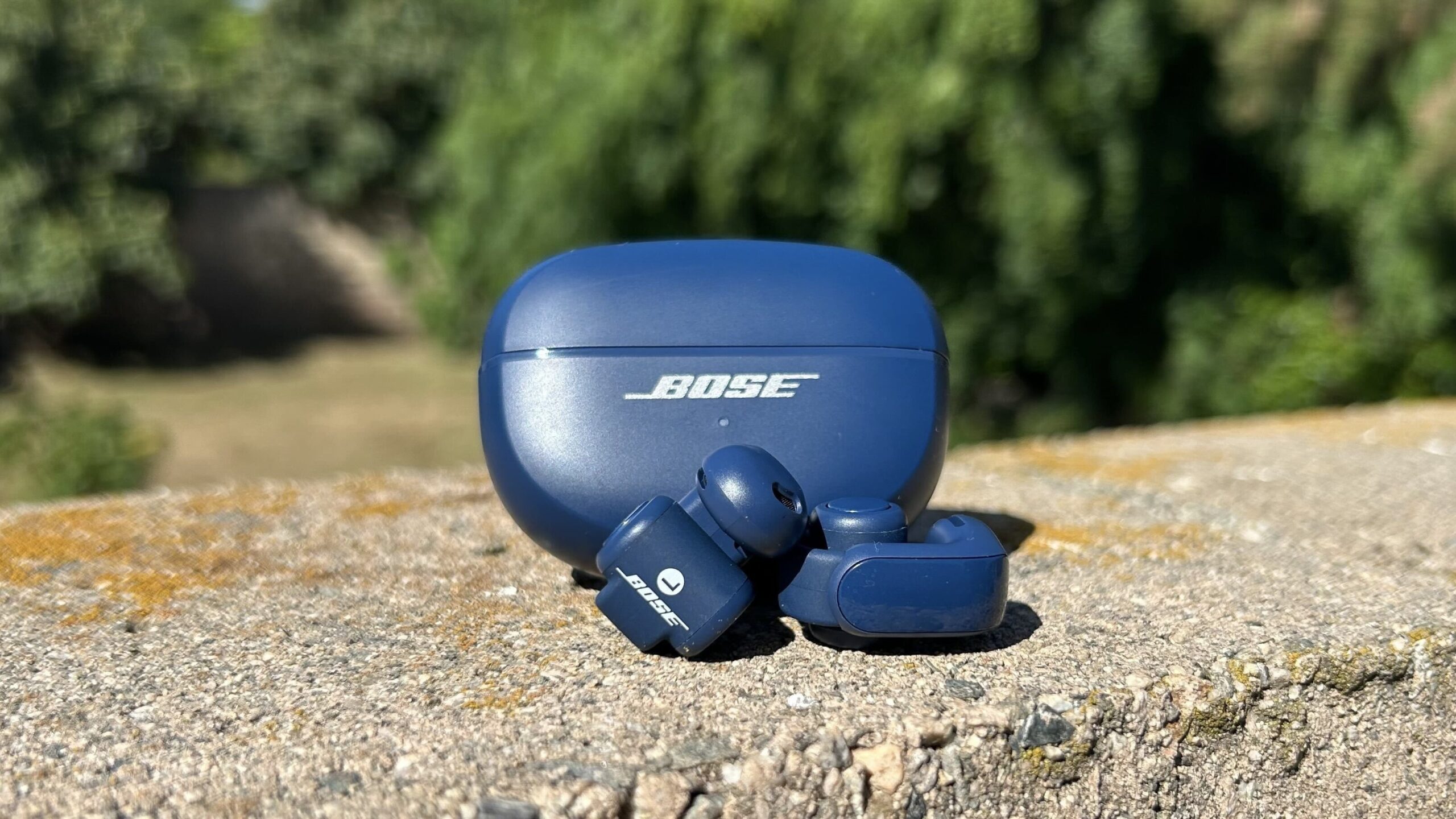 bose open earbuds with charging case on sidewalk