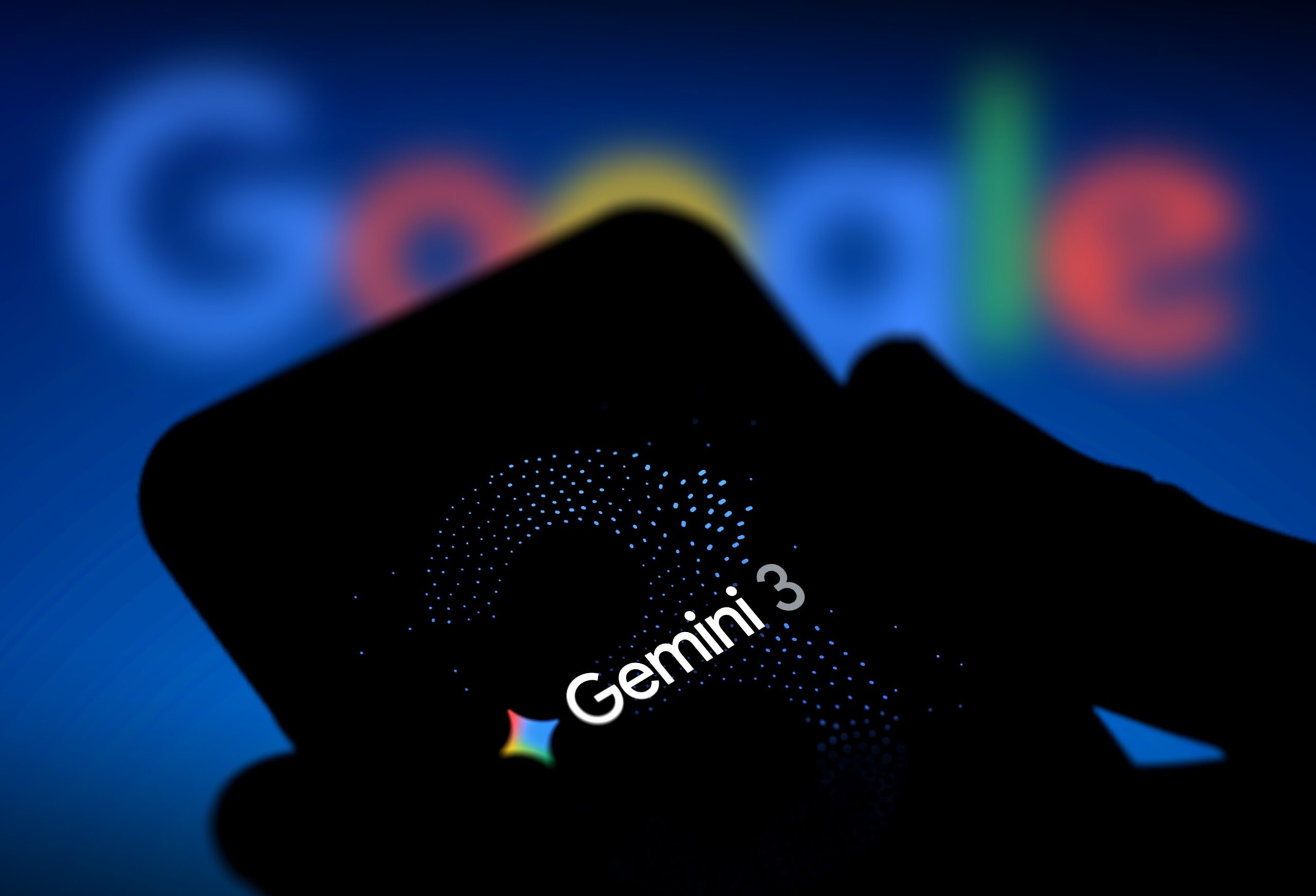 the logo of Gemini 3 is displayed on a smartphone screen with Google logo in the background