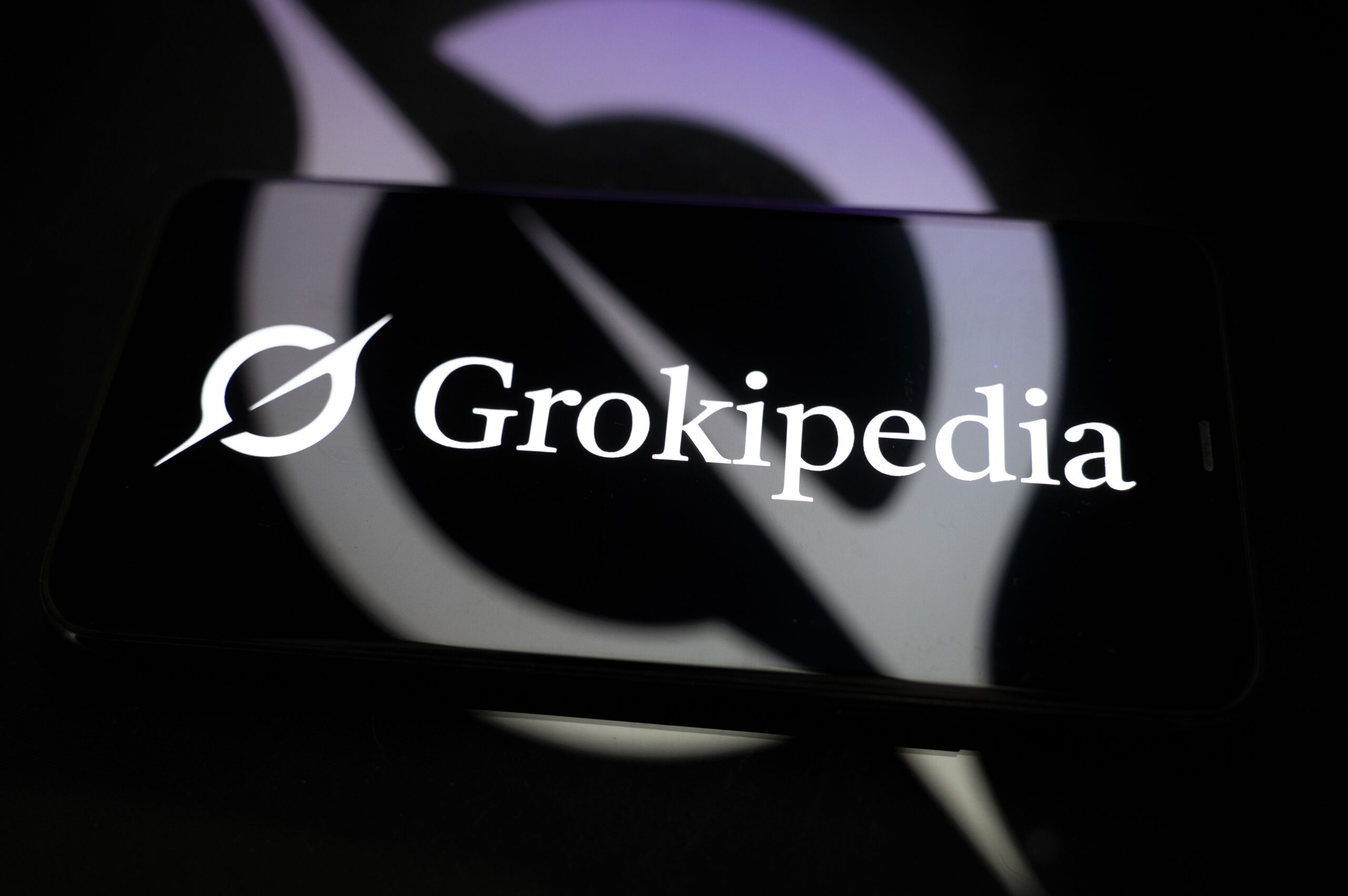 The Grokipedia logo reflected off a phone screen. 