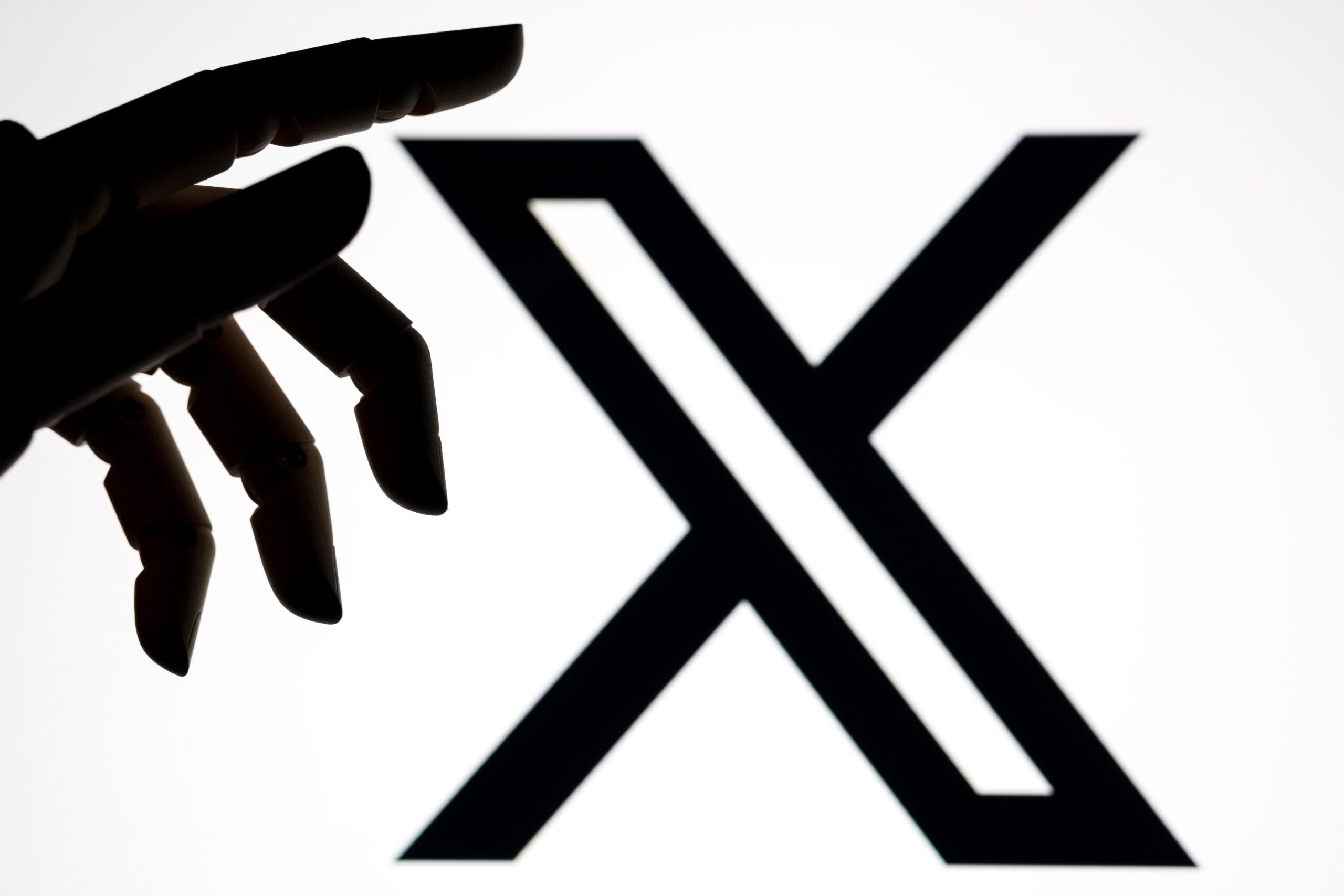X logo with robot hand