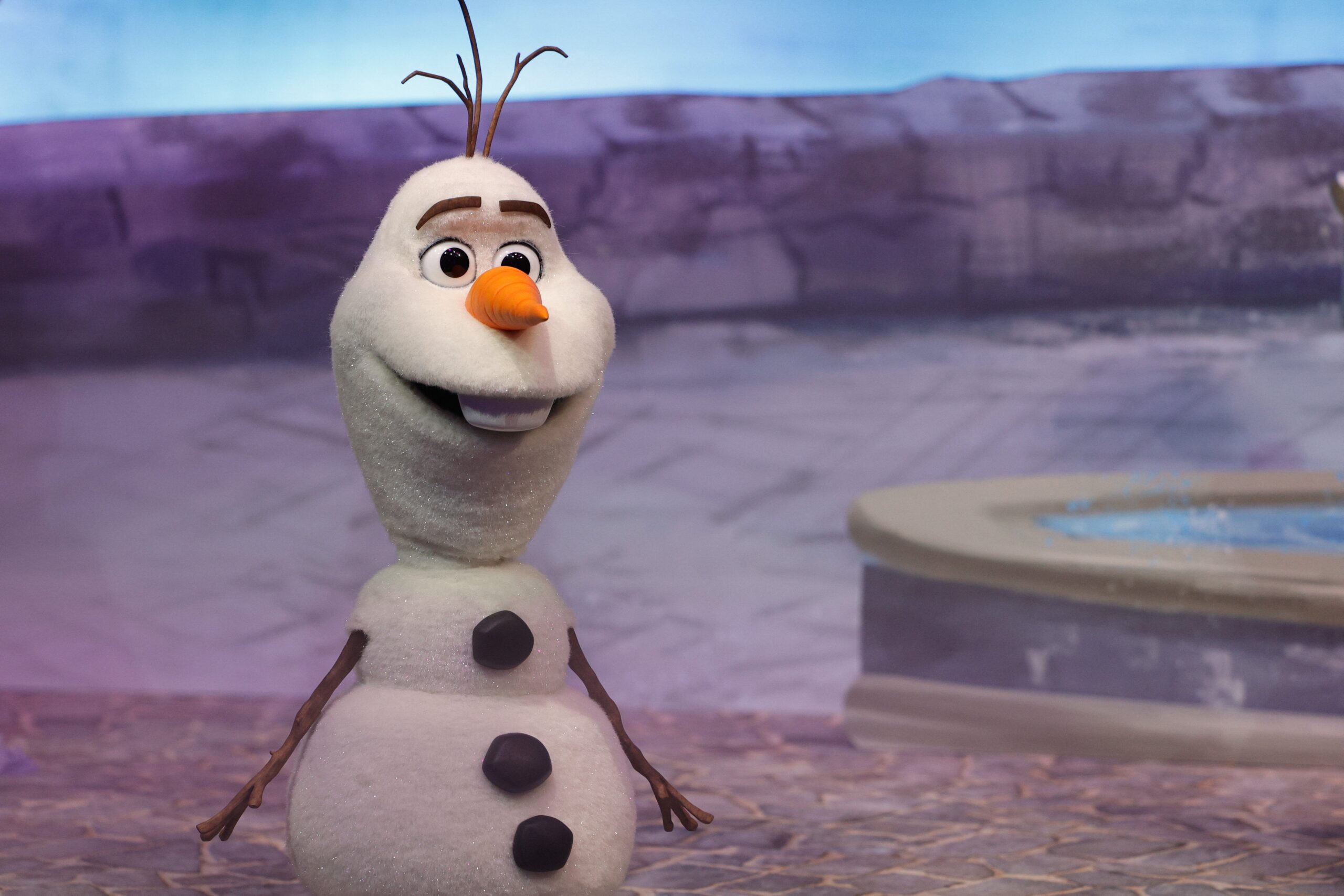 A life-size Olaf robot stares blankly at the camera.