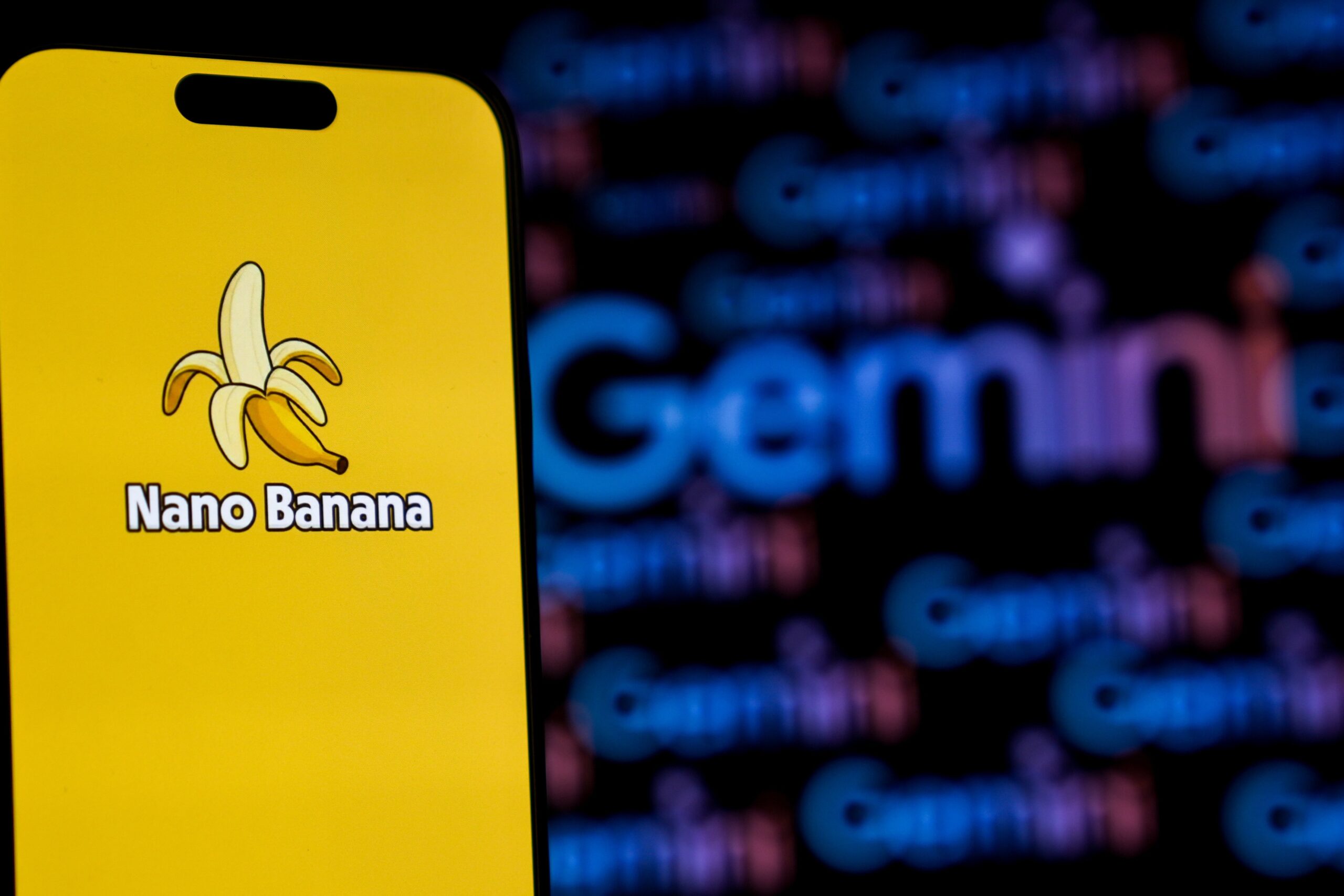 The Nano Banana logo is displayed on a phone screen in front of a screen showing the Gemini logo in Ankara, Turkiye, on October 24, 2025. 