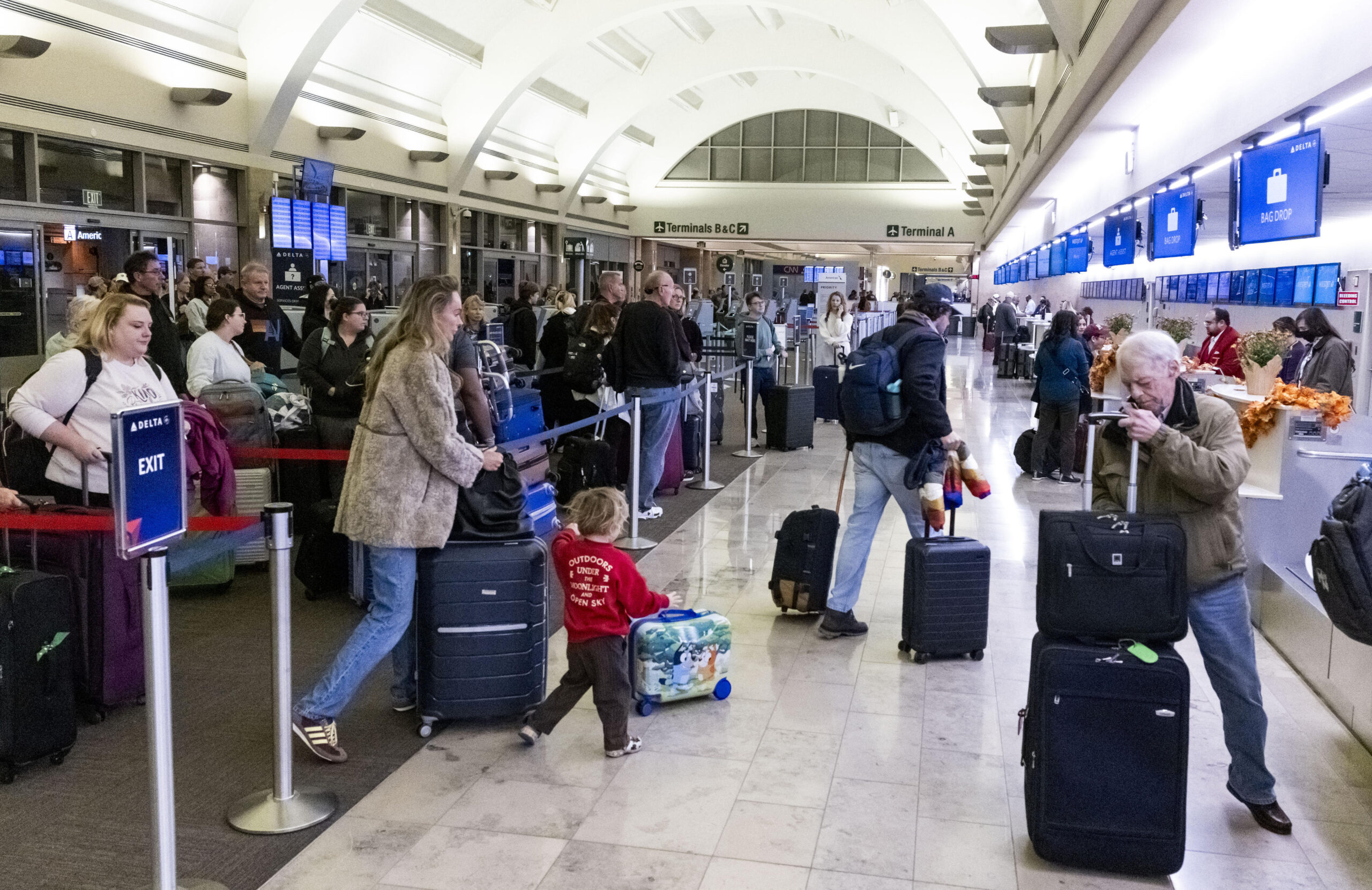 Travelers wait to check bags at the start of the Thanksgiving holiday at John Wayne Airport in Santa Ana, CA on Monday, November 24, 2025. The Auto Club projects 6.78 million residents in Southern California will travel 50 miles or more from home during the Thanksgiving holiday travel period, marking a 2.8% increase over last year and setting a new record for this holiday.