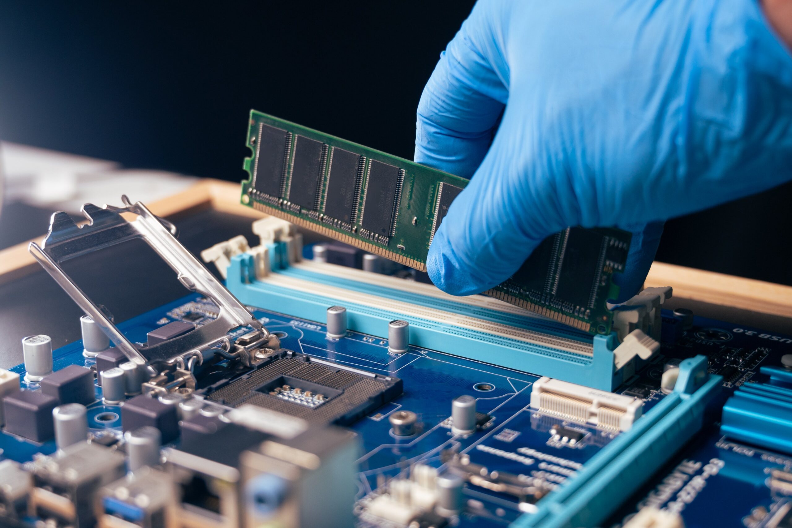 The technician installing the RAM on the computer's motherboard
