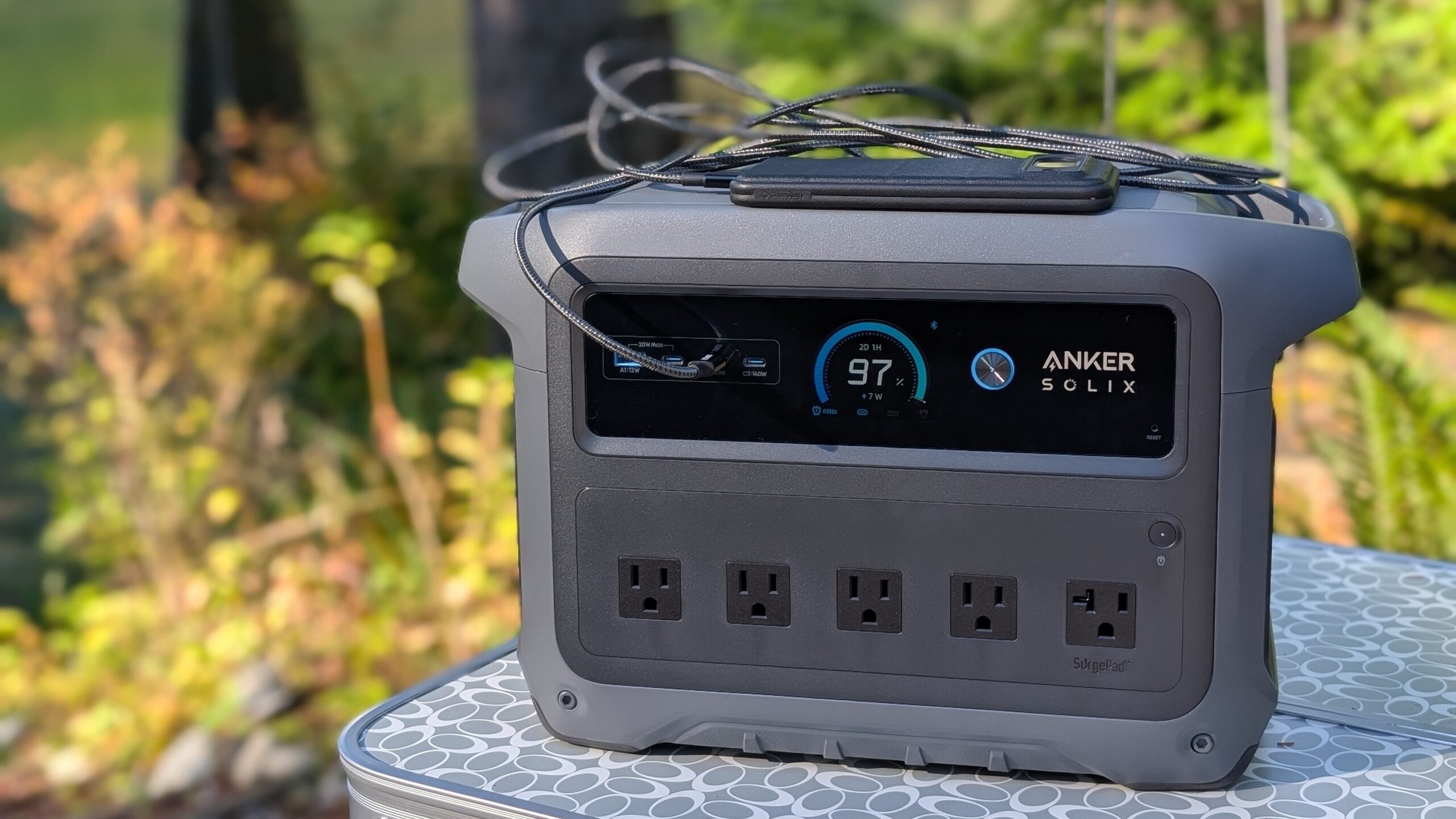 the anker solix c1000 gen 2 outside on a table with a cellphone resting on top of it