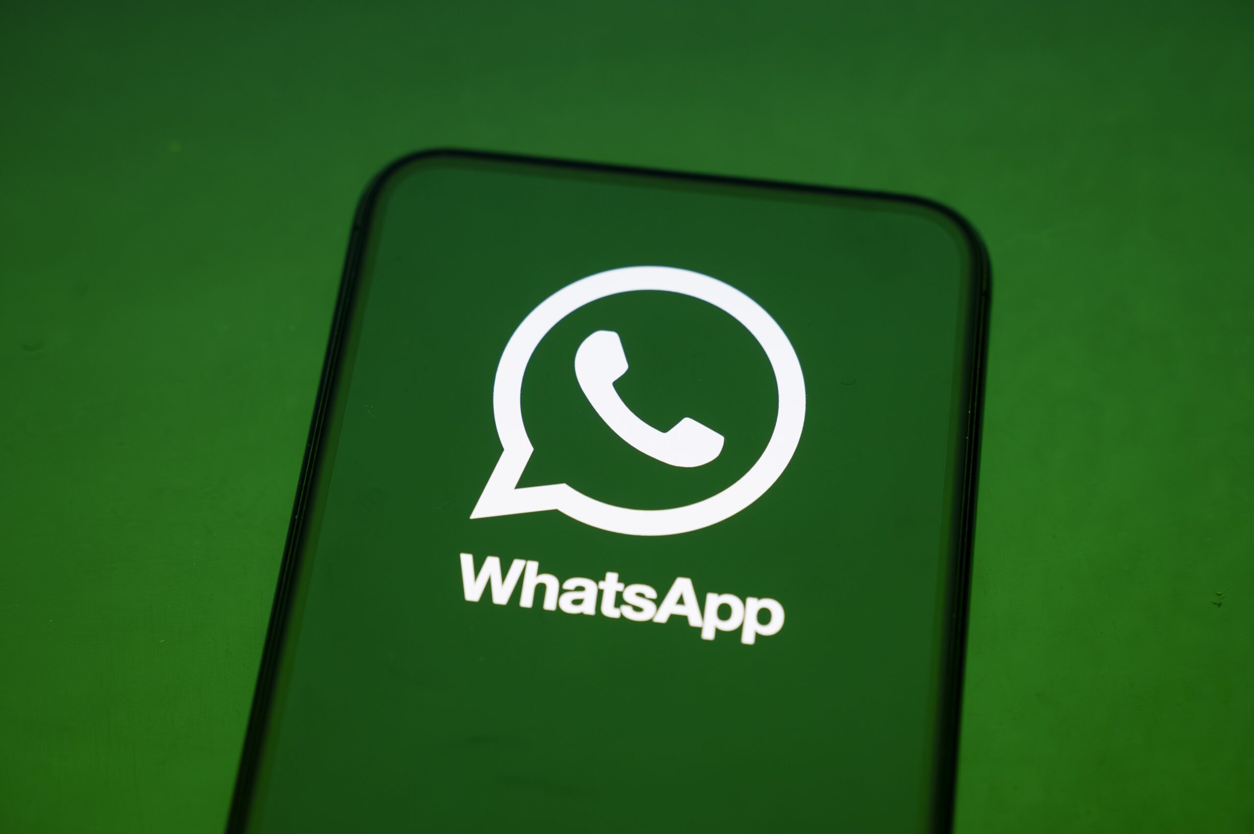 WhatsApp logo on a phone.
