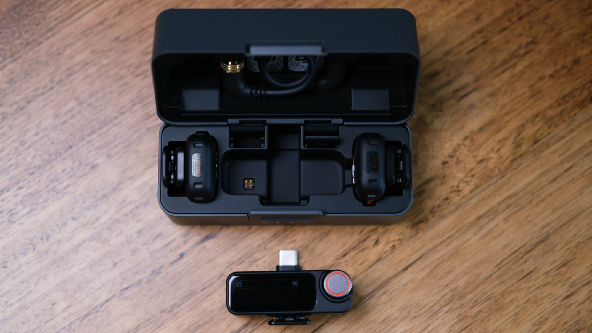 The DJI Mic 3 in its open charging case, with the reciever outside the case.