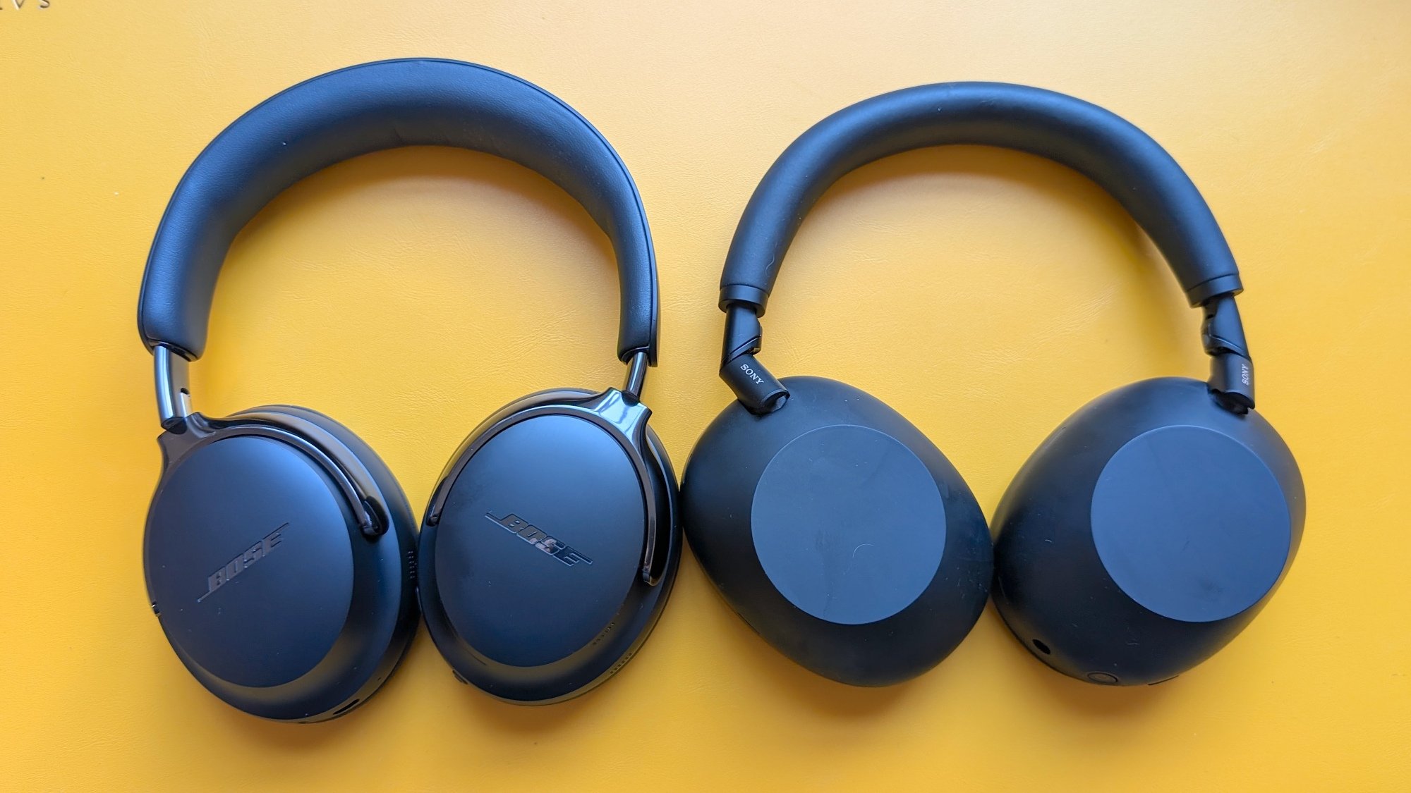 The Bose QC Ultra (Gen 2) and Sony XM6 headphones lon a yellow background.
