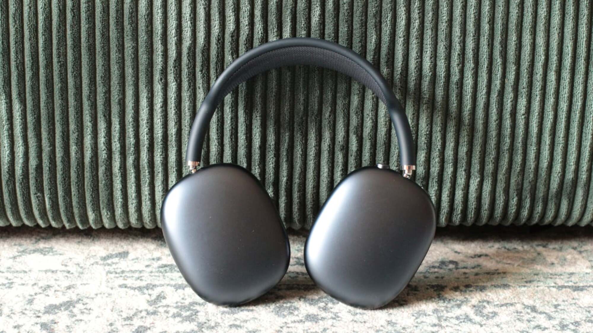 black airpods max leaned against cushion
