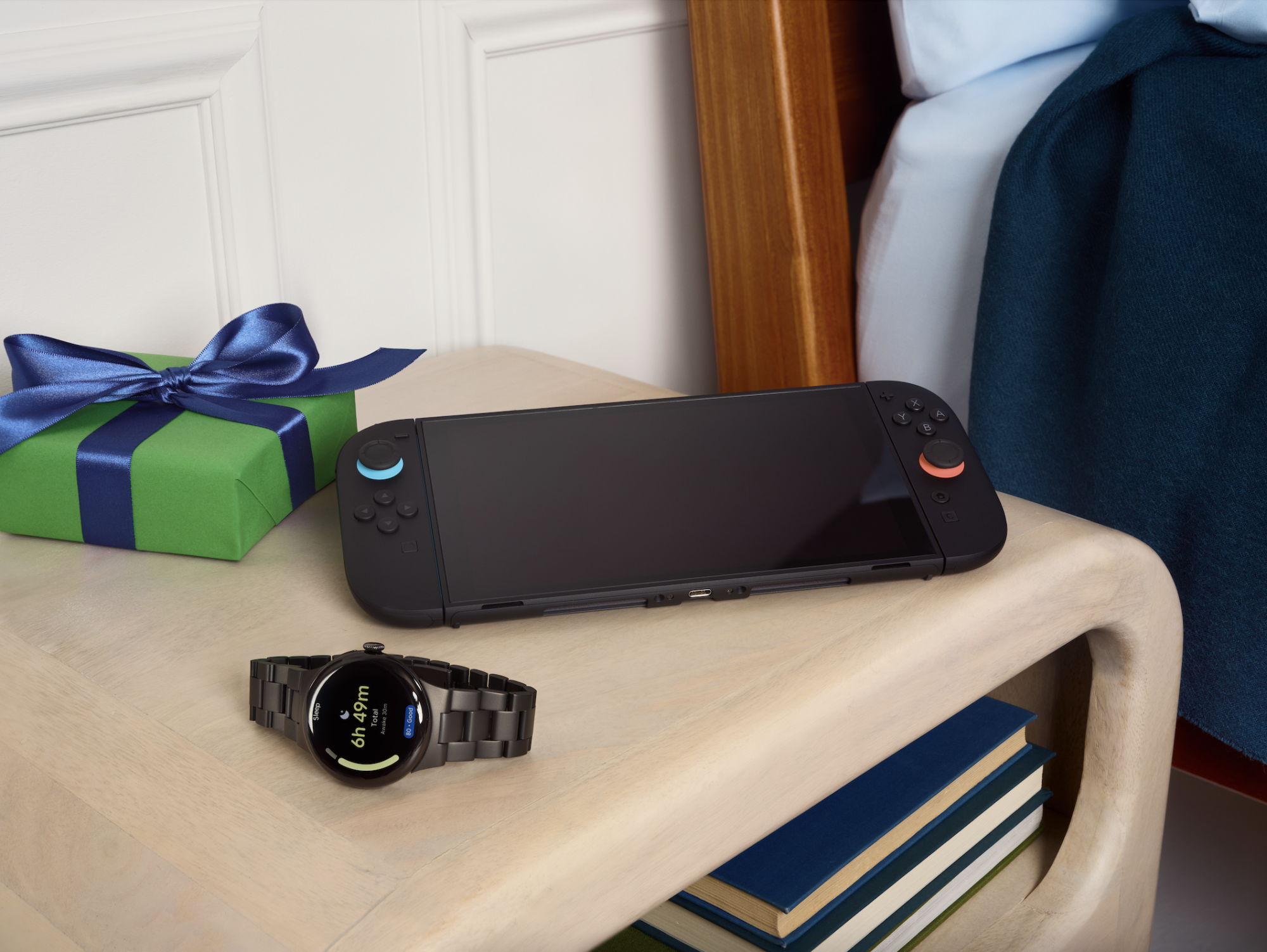 a nintendo switch 2 and a google pixel watch 4 on a bedside table
