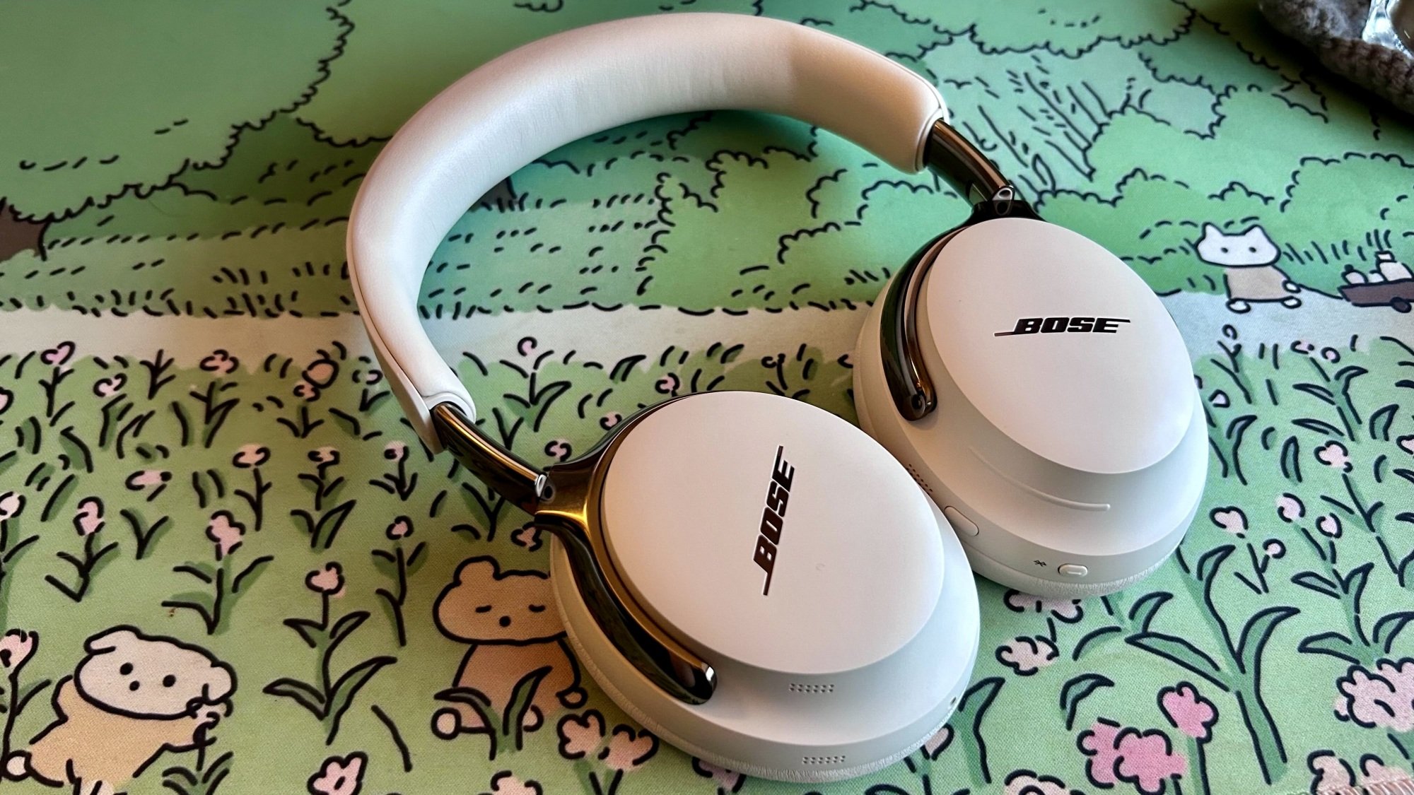 bose qc ultra headphones laid flat on desk mat
