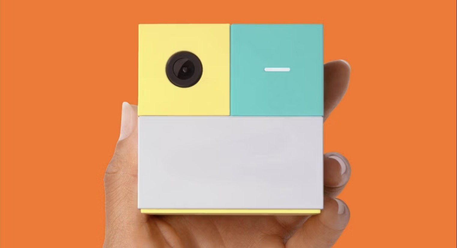 Nex Playground in person's hand in front of orange background