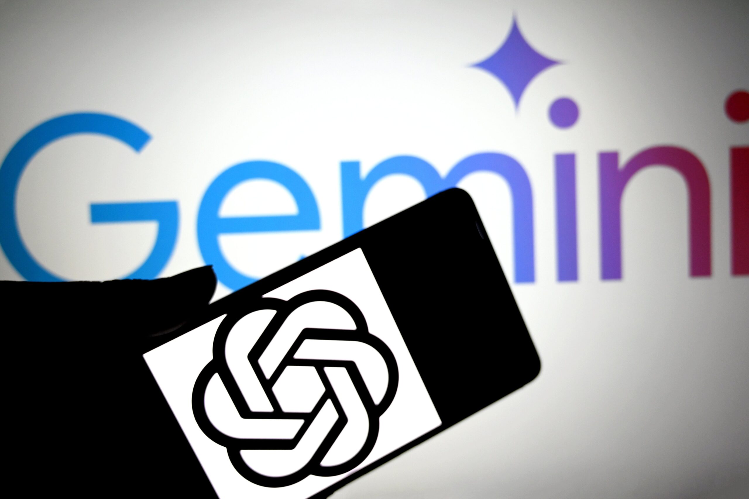 OpenAI logo on mobile device with Gemini logo in the background