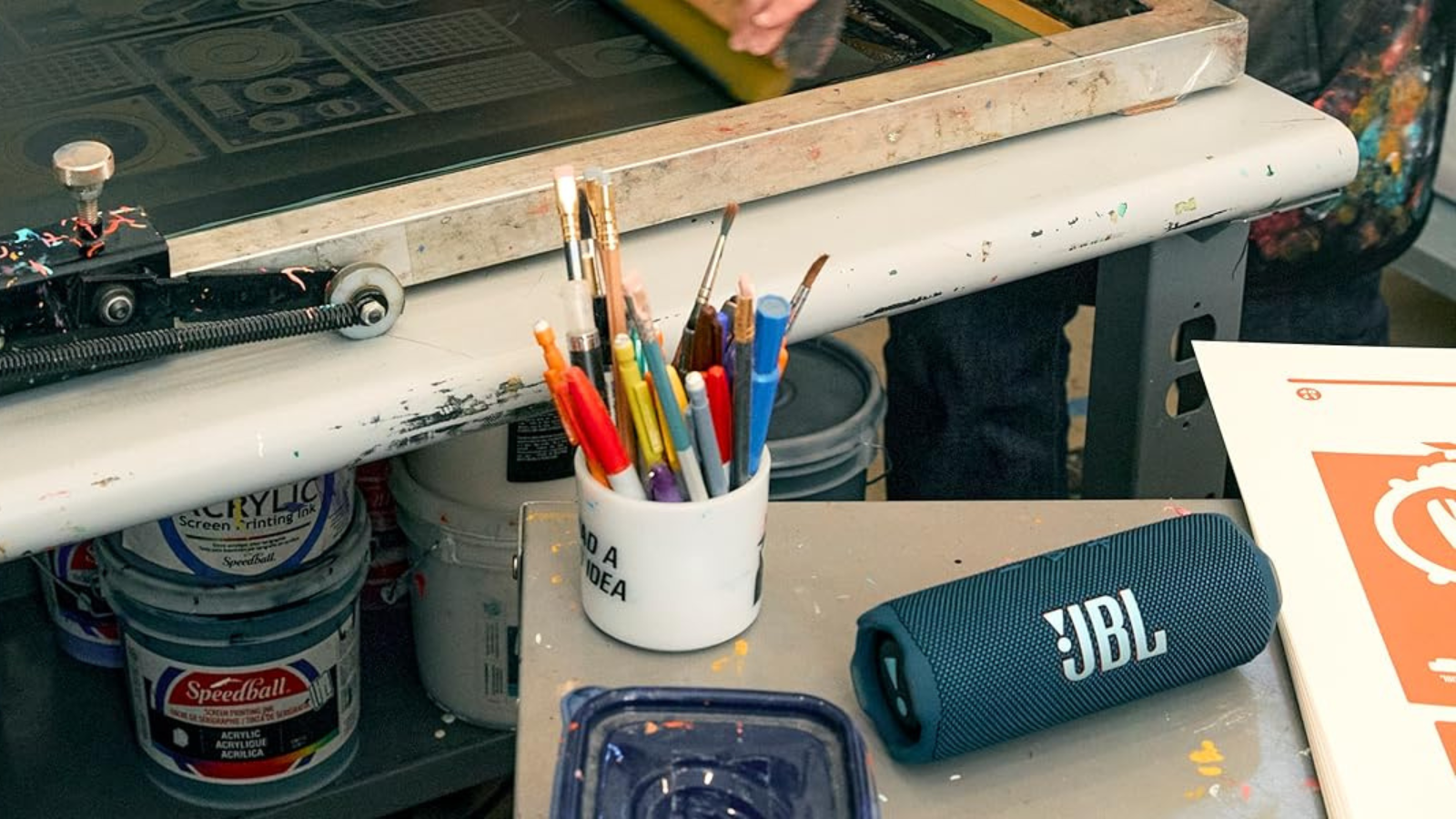 JBL Flip 7 speaker on desk with art supplies