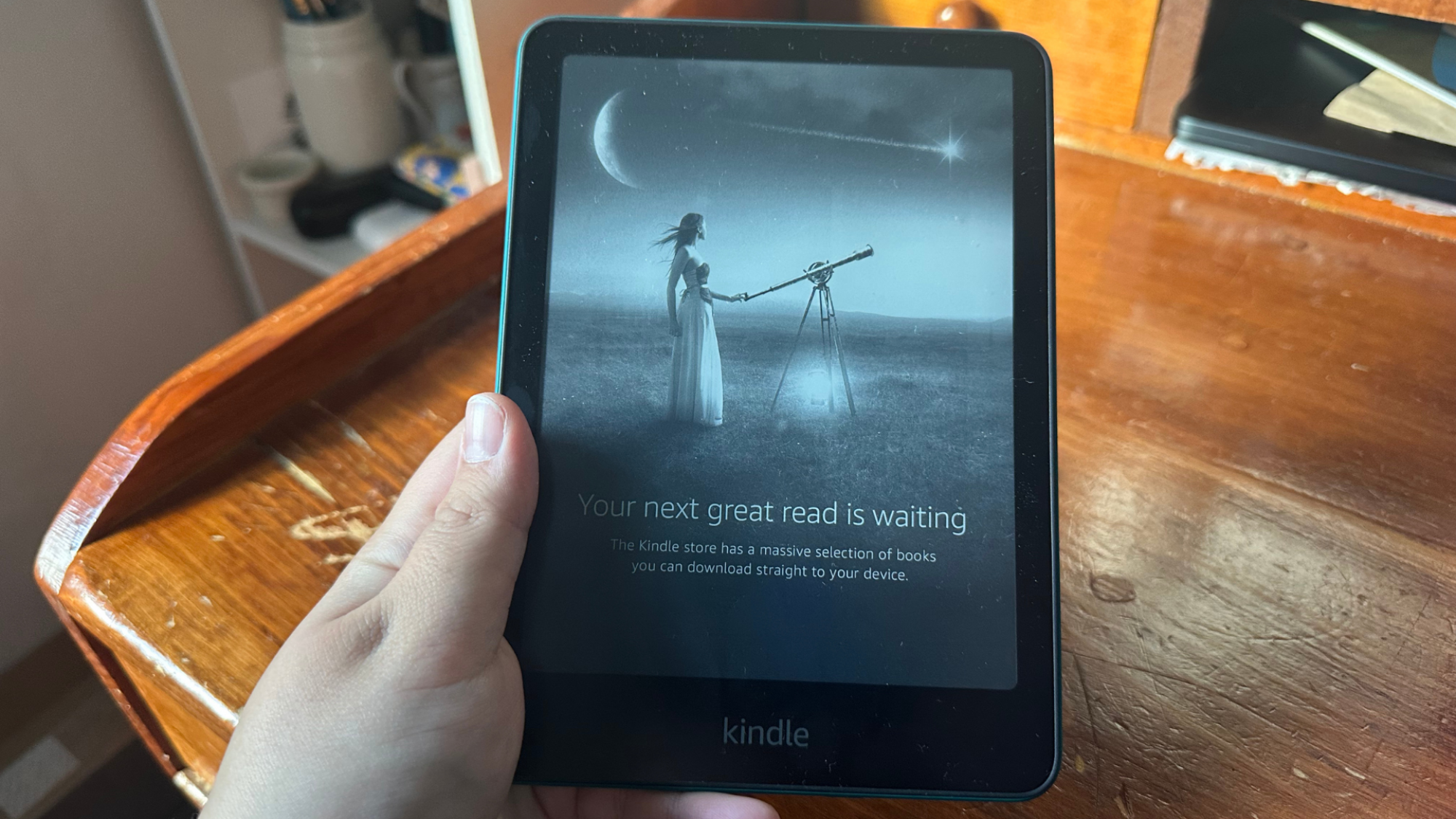 close up of hand holding Kindle Paperwhite device