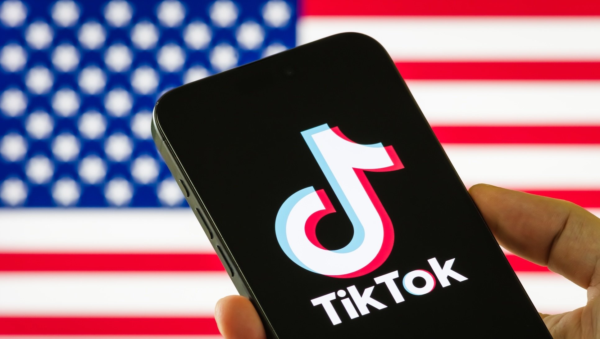 The TikTok app on a smartphone in front of the U.S. flag