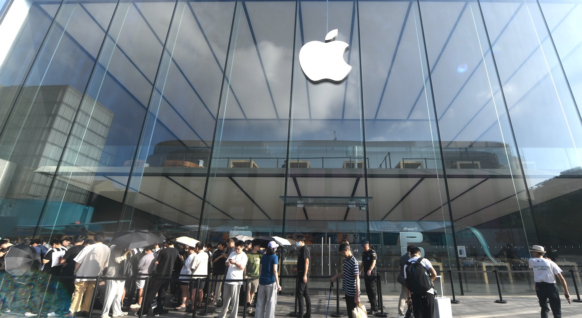 An Apple Store with a line of people outside.