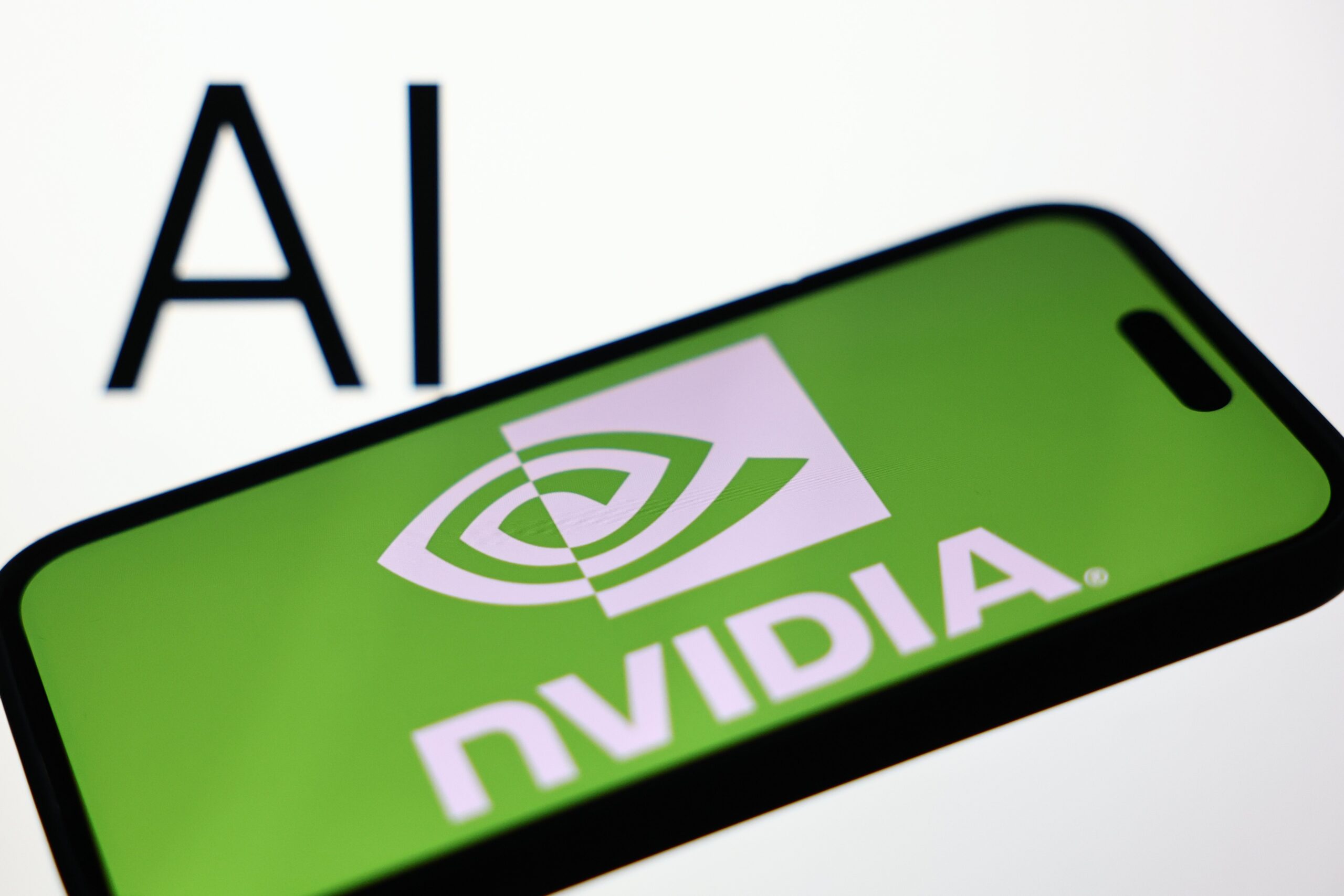 AI sign displayed on a screen and Nvidia logo displayed on a phone screen are seen in this illustration photo taken in Krakow, Poland on December 23, 2025.