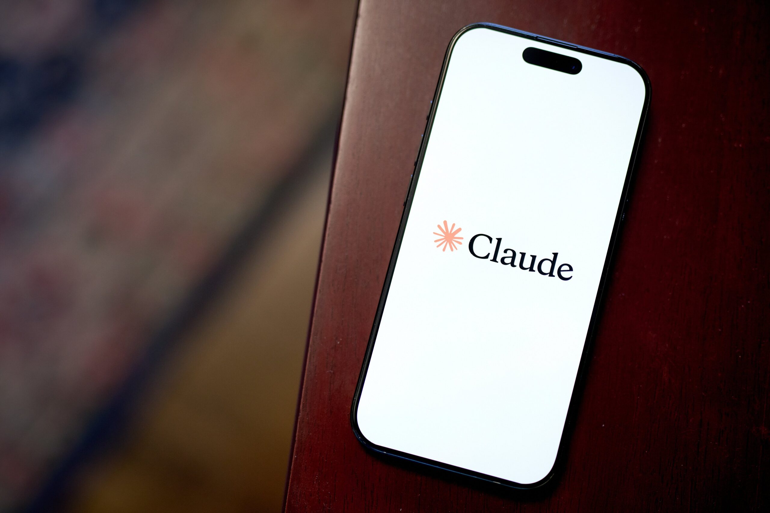 A phone displays the Claude logo.
