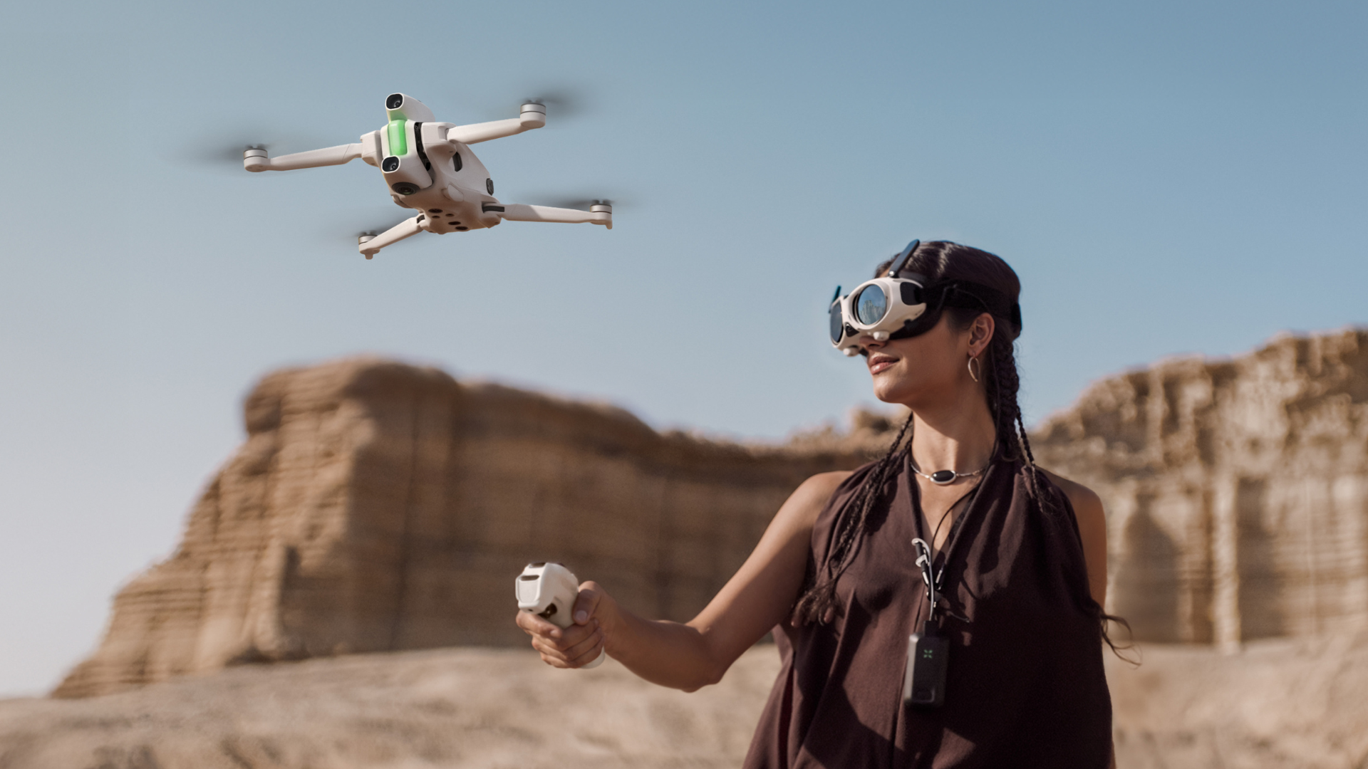 A woman piloting an Antigravity A1 drone, wearing the Vision goggles and using the Grip controller.