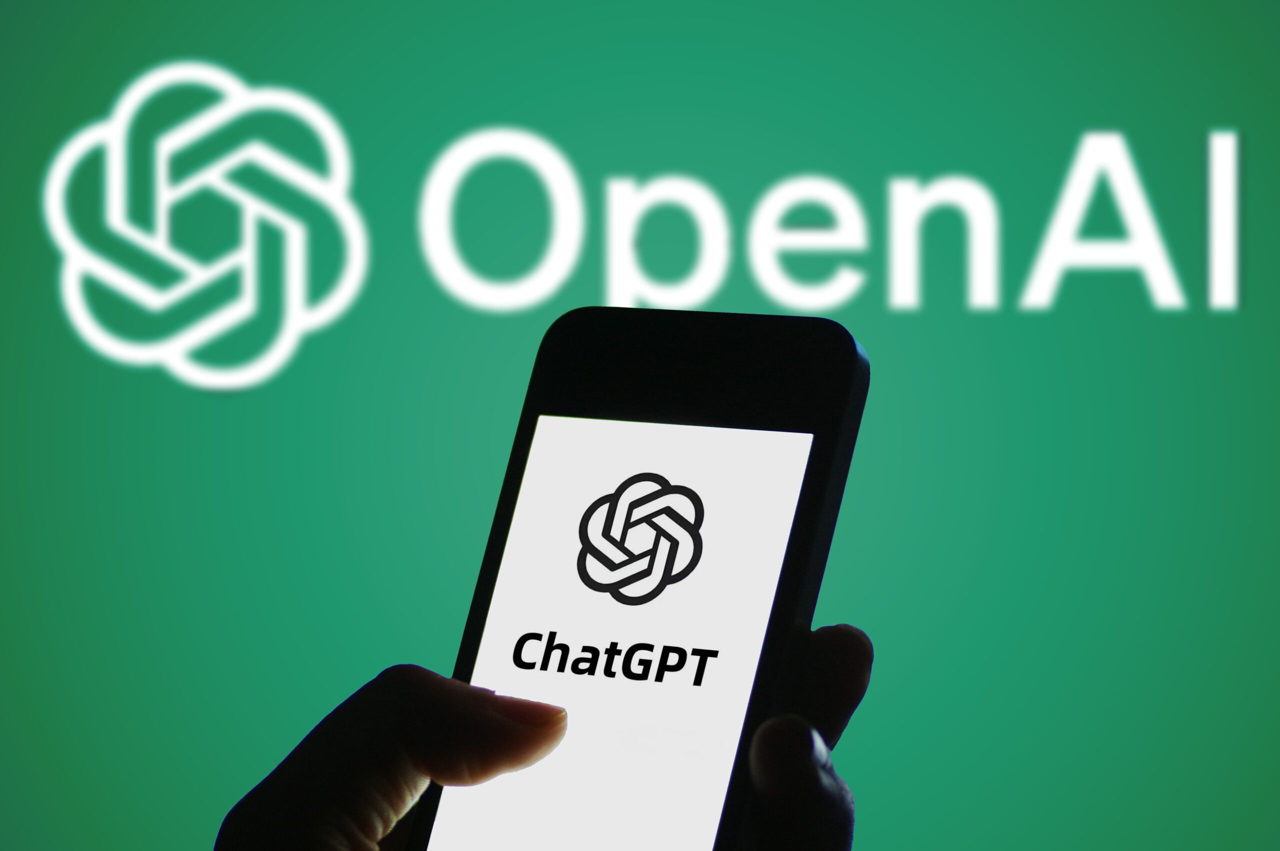 chatgpt logo on phone screen with open ai logo behind it
