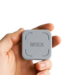 A hand holding the Brick device