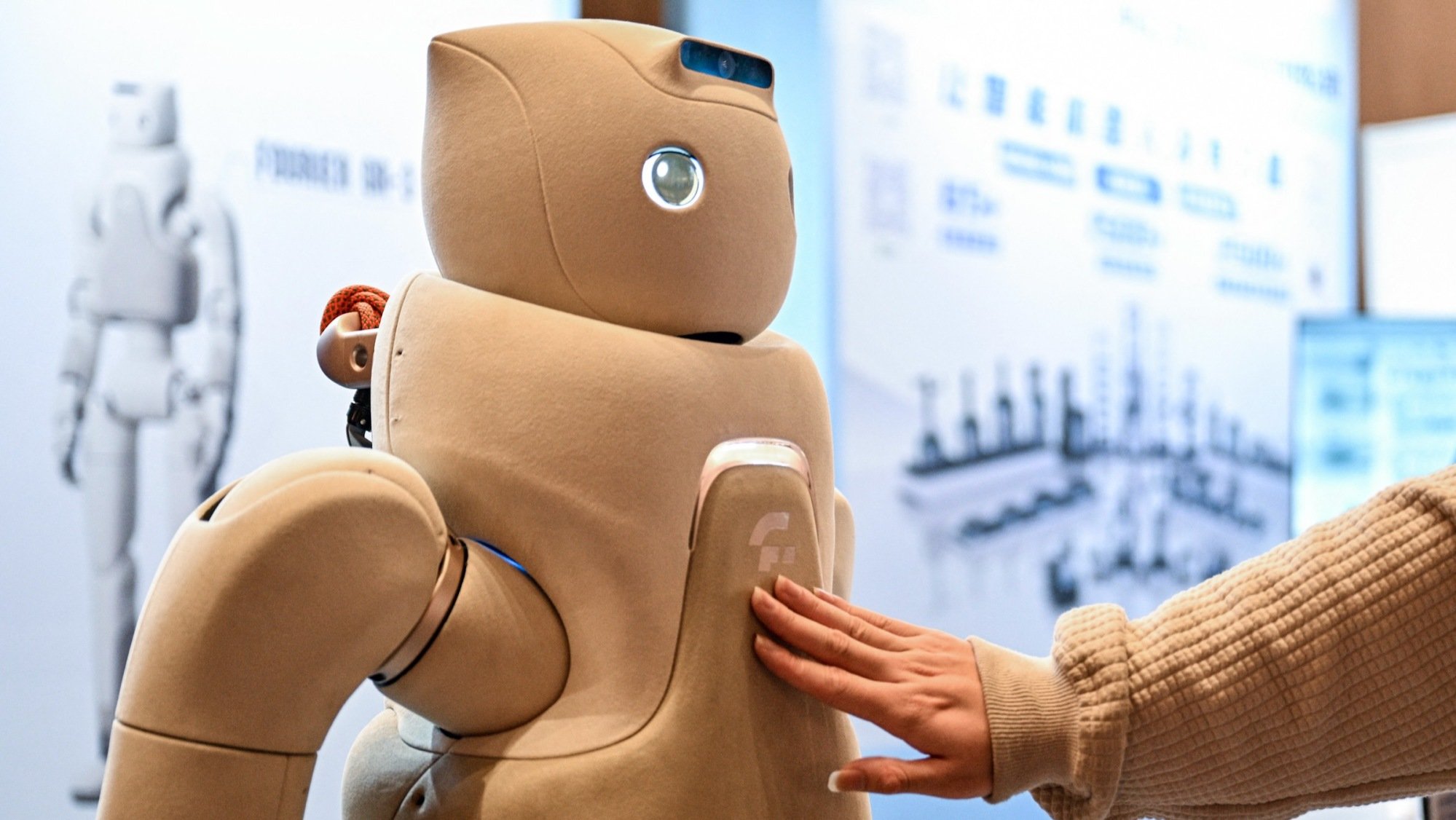 a person touches the Fourier GR-3 companion robot on display in Shanghai