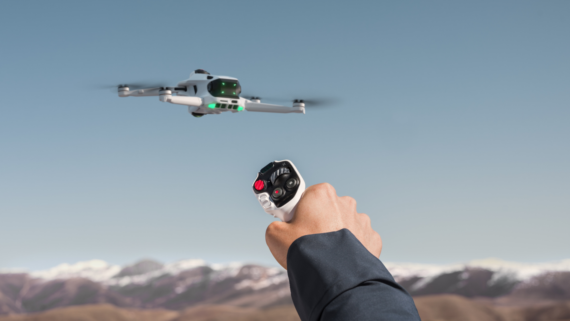 The Antigravity A1 drone in the air. An extended hand controls it with the Grip controller.