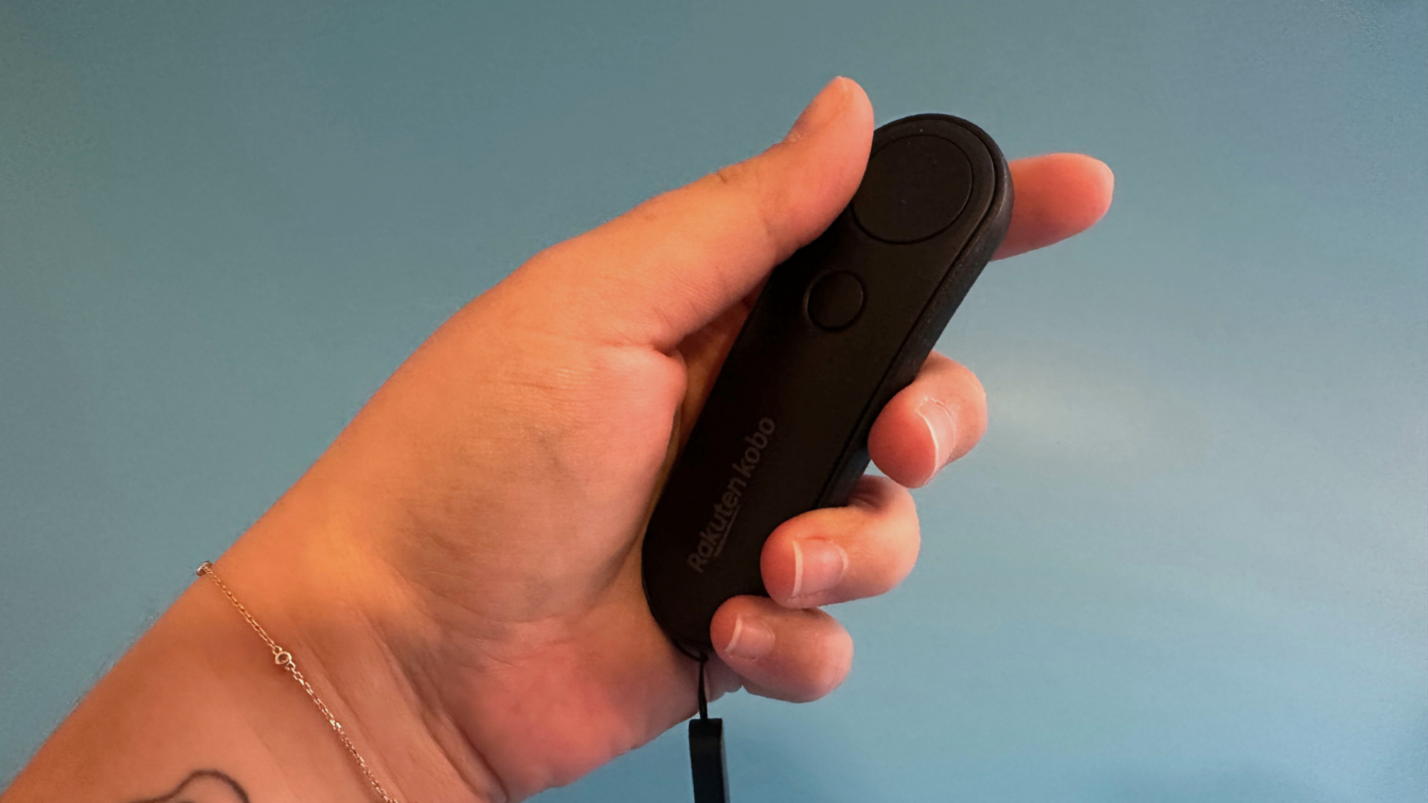 A hand holding the Kobo Remote