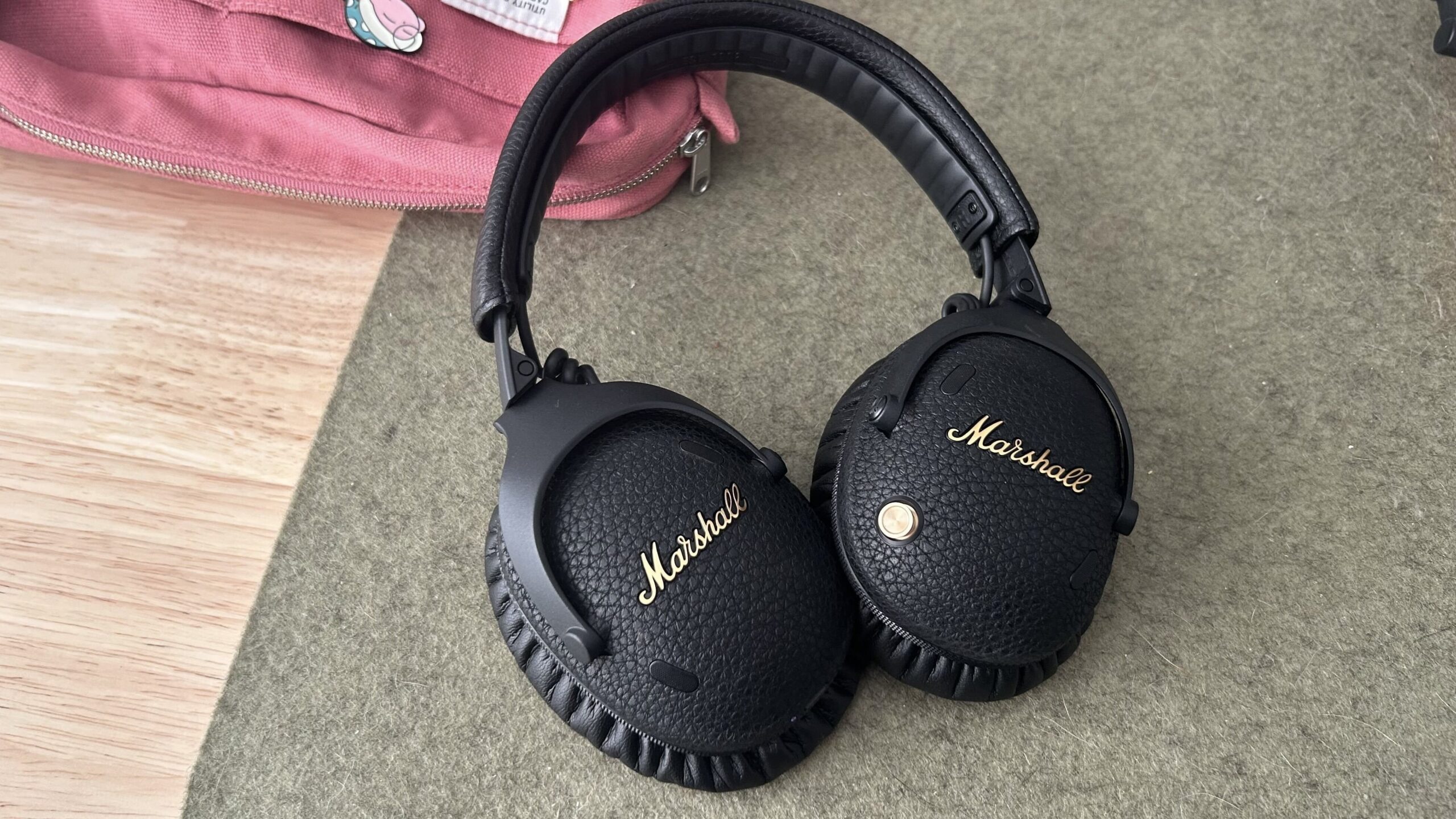 marshall headphones resting on green desk mat and pink canvas pouch